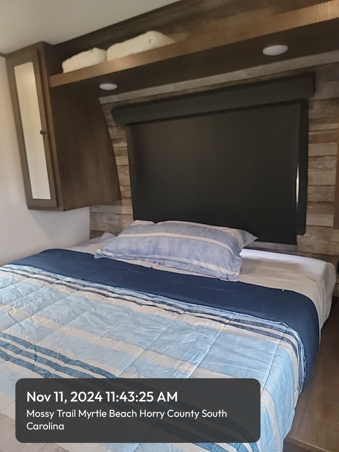 Cozy rv rental bed with striped bedding & overhead storage, perfect for a comfortable night's sleep in a camper.. Forest River Hyperlite HD 2021