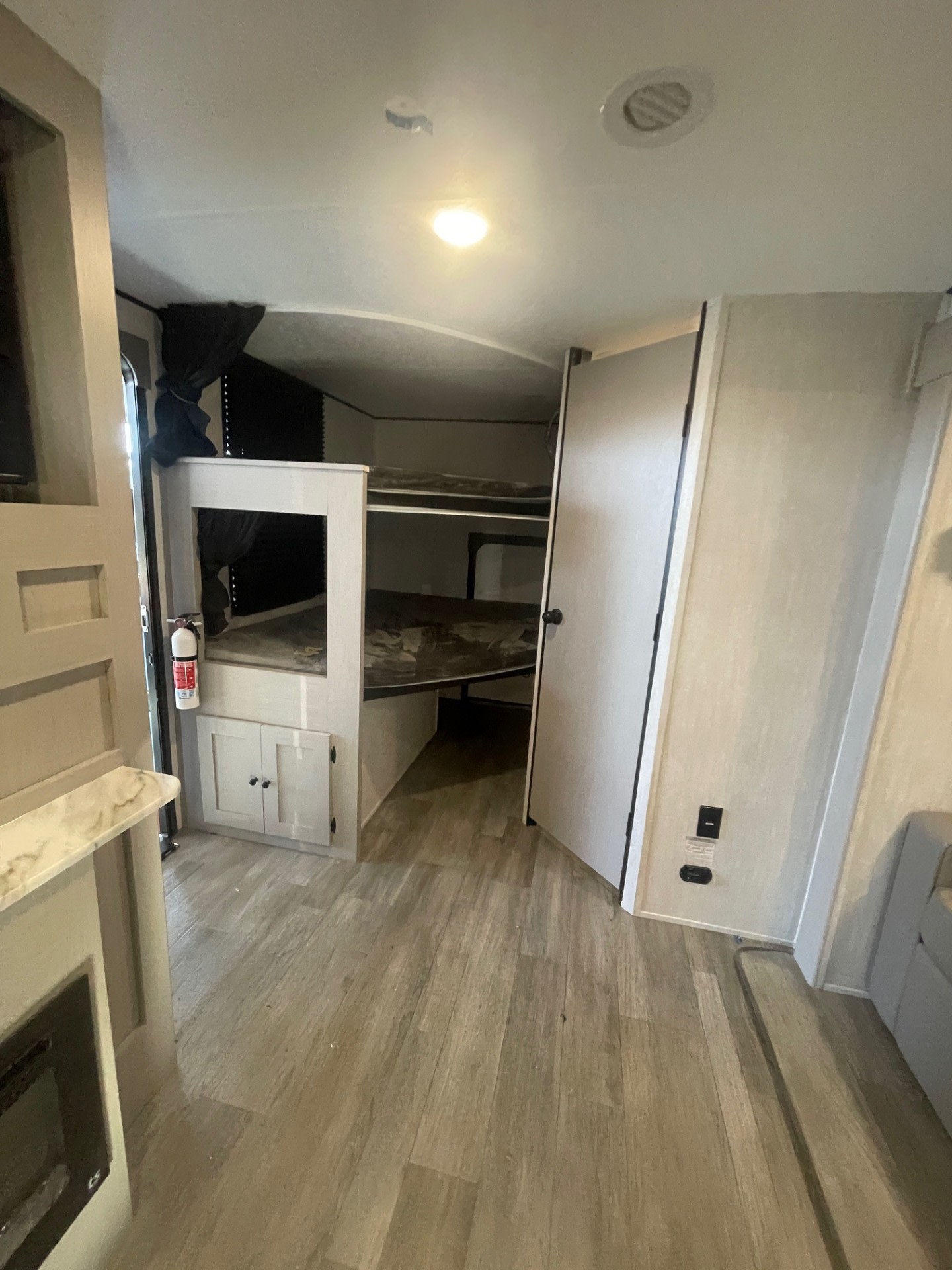 Explore this RV rental's modern interior: a bright living area with bunk beds, wood flooring, and practical features.. Coachmen APEX 284BHSS 2025