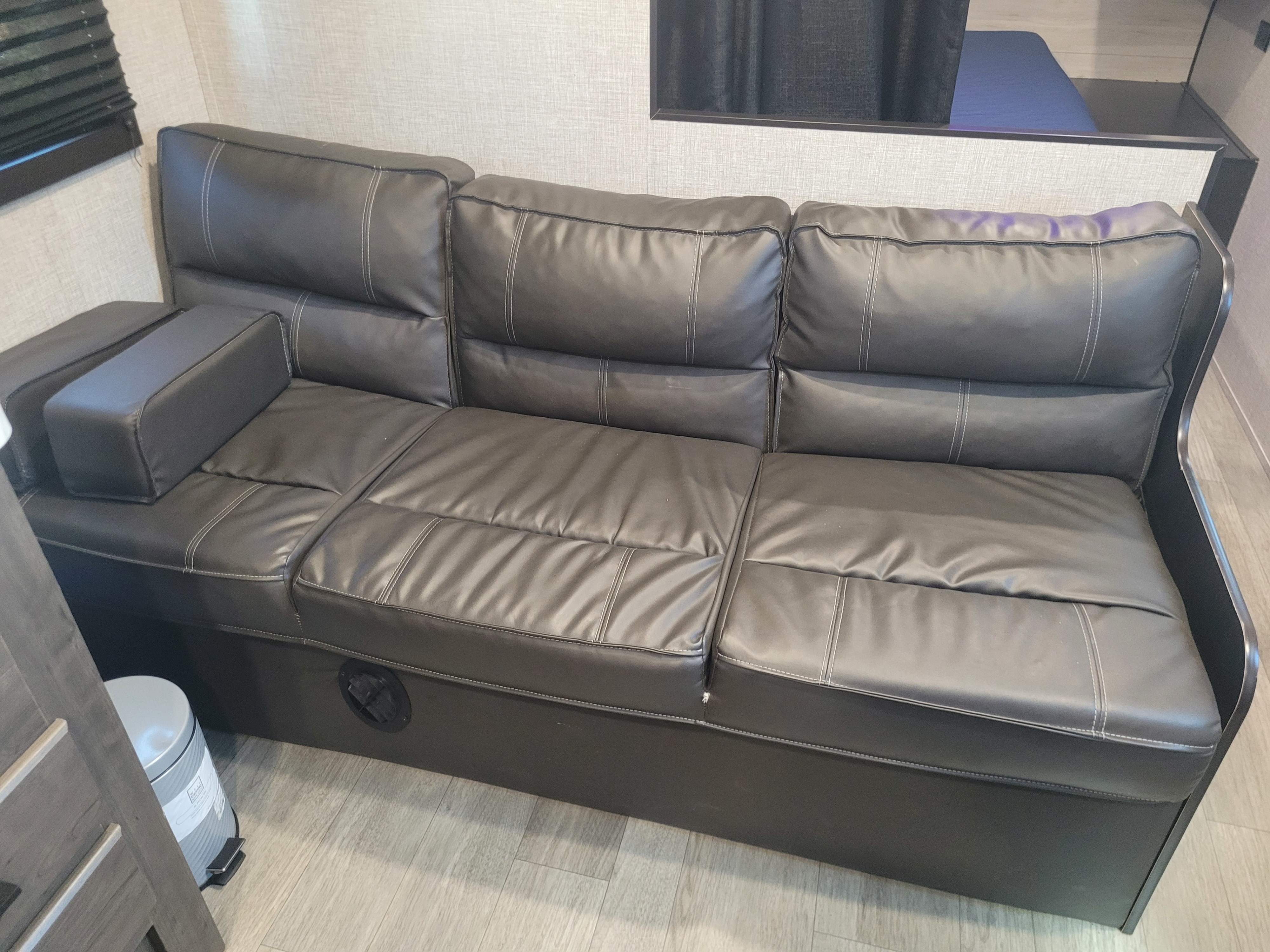 RV rental: Modern dark gray sofa with white stitching and convertible design for comfortable seating.. Jayco Jay Flight 2022