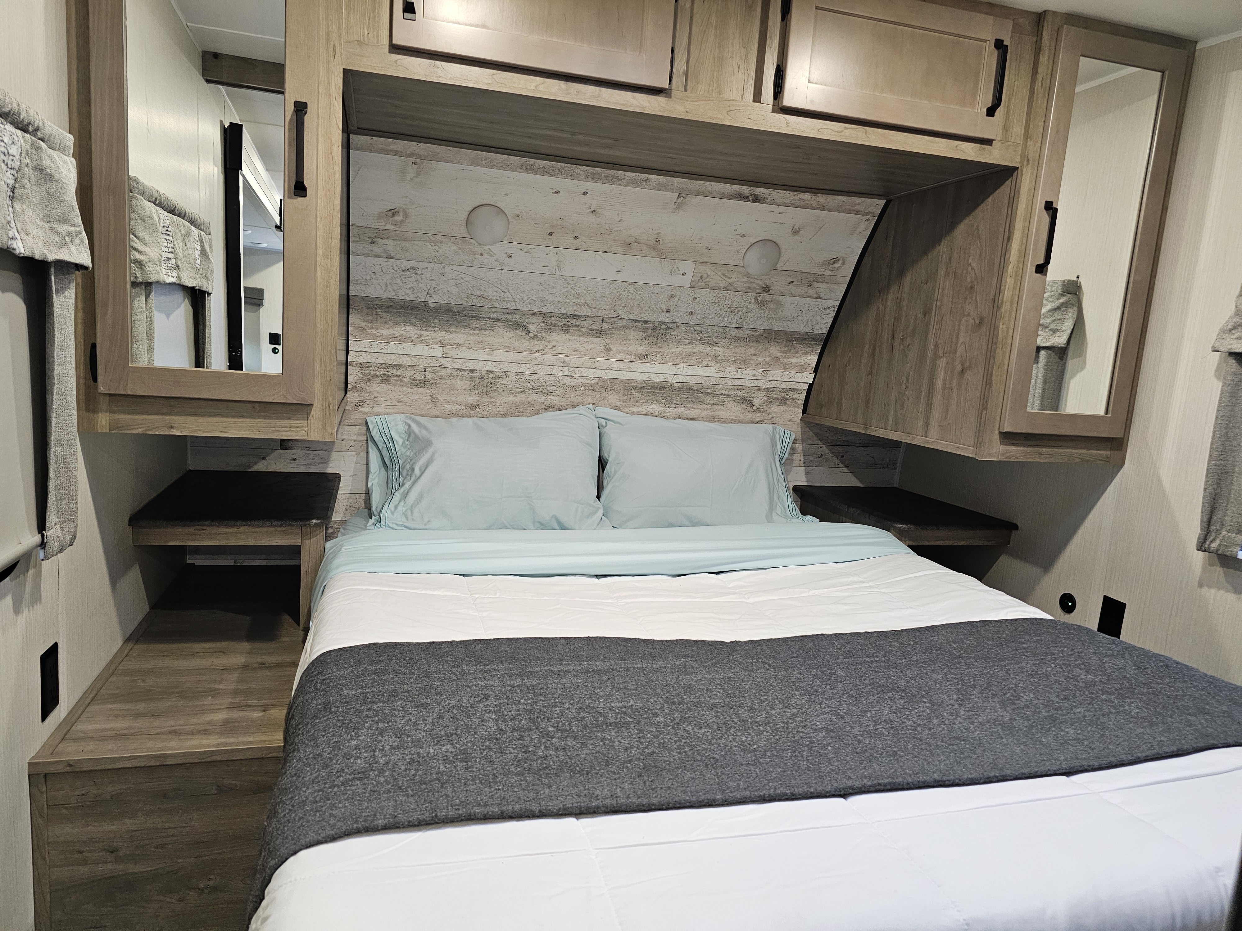RV rental bedroom with a comfy bed, overhead cabinets, and built-in nightstands for your next adventure.. Palomino Puma 2023