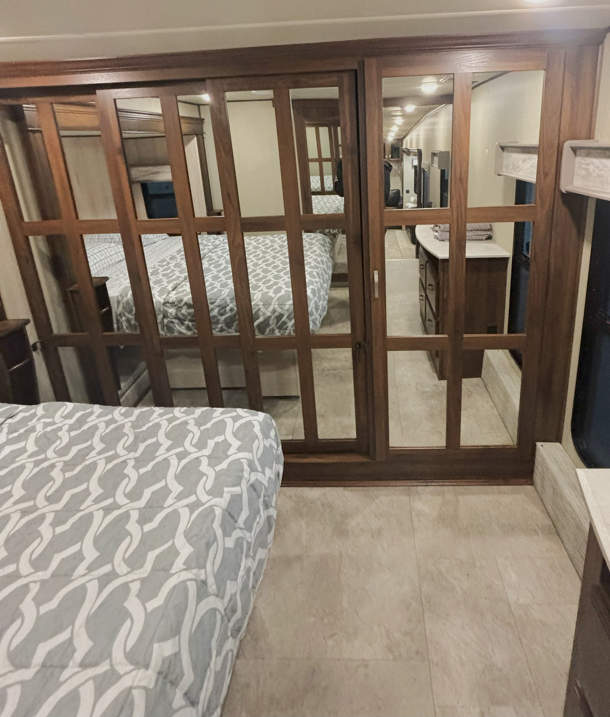 RV rental: Mirrored closet doors in this bedroom reflect the patterned bed, dresser, and interior lighting.. Palomino Columbus 2021