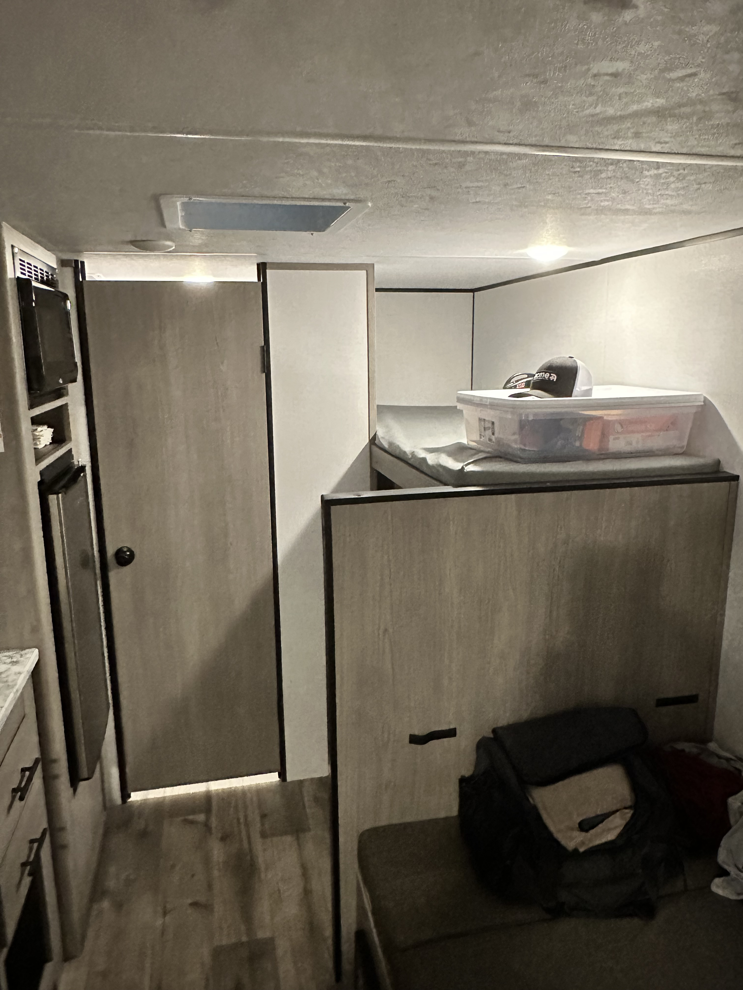 RV rental interior with compact kitchen, bathroom door, and bunk beds for travel adventure.. Coleman Coleman lantern 17b 2024