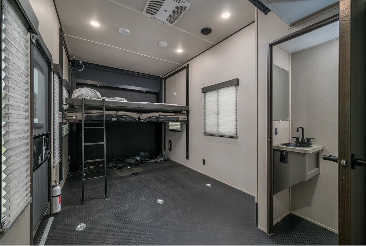This RV rental's toy hauler garage features a raised bunk bed, rubber floor, and accessible bathroom.. Grand Design Momentum 2021
