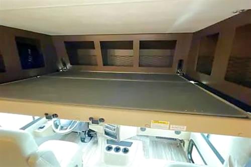 Inside this rv rental, a large cab-over bunk with wooden storage is visible above the driver's cockpit.. Thor Motor Coach A.C.E 2022