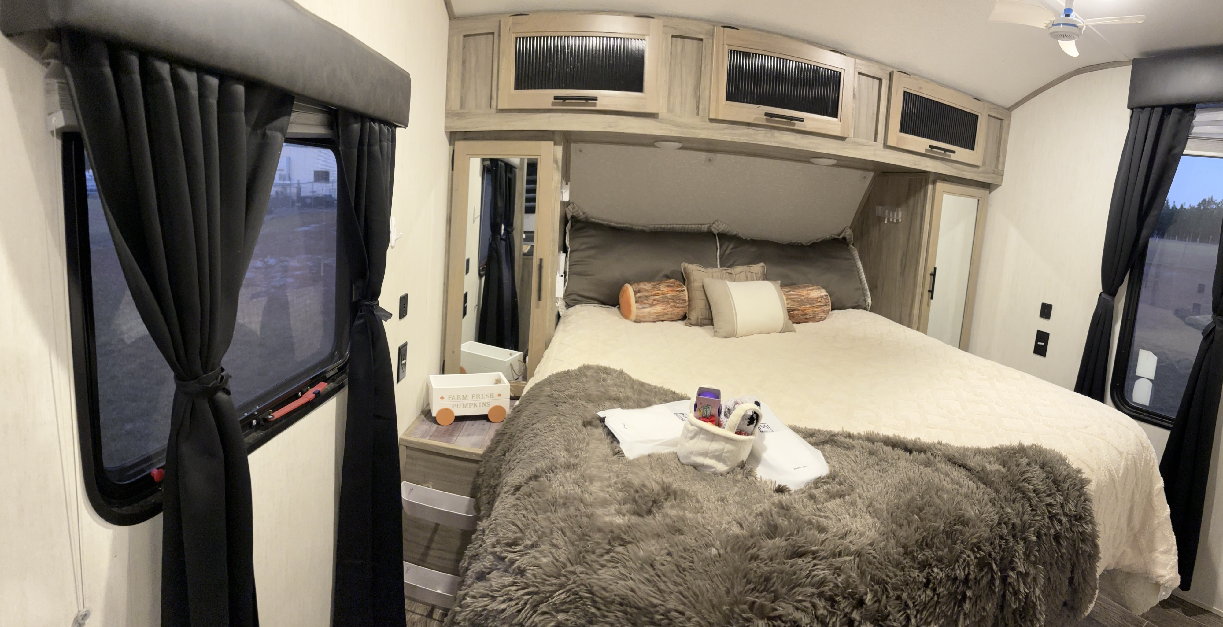 Cozy RV rental bedroom features a comfy bed, modern cabinets, and blackout curtains for privacy.. Forest River Cherokee Alpha Wolf 2022