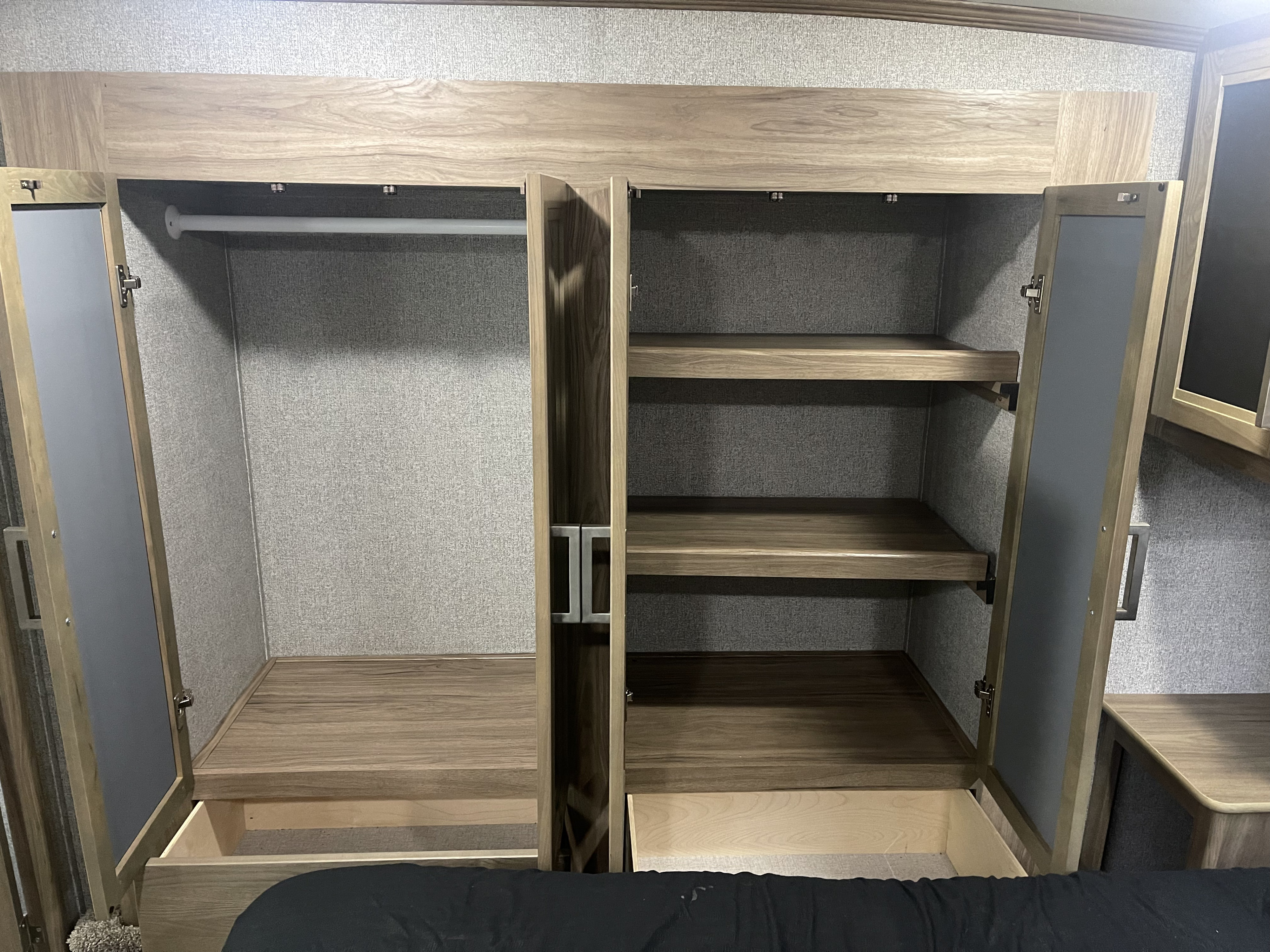 RV rental wardrobe: spacious closet with a hanging rod, multiple shelves, and pull-out drawers for ample storage.. Dutchmen 3586 2019
