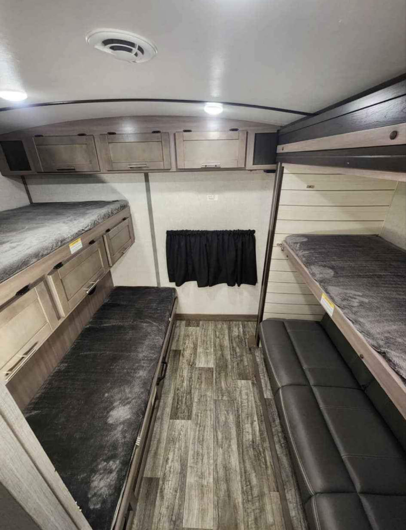 Explore this RV rental's cozy interior, showcasing compact bunk beds, practical overhead storage, and versatile seating areas.. Crossroads Sunset Trail Super Lite 2021