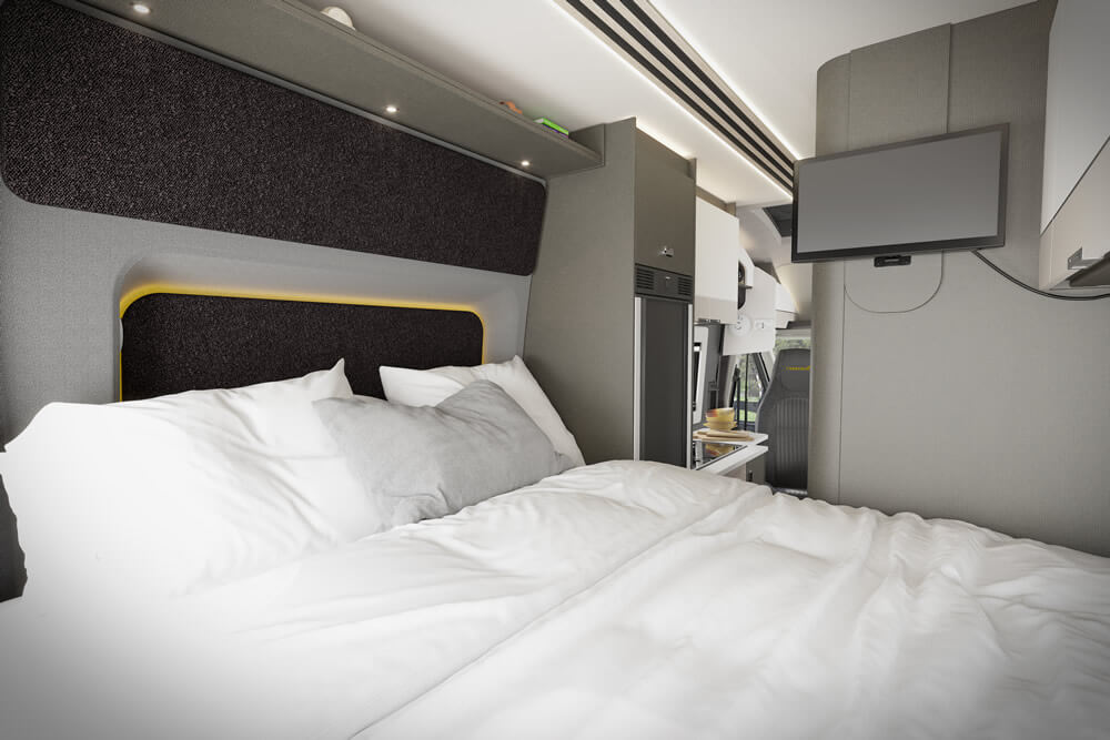Cozy RV rental bedroom with a comfy bed, modern headboard, ambient yellow lighting, and a wall-mounted TV for your travels.. Ford Trekker X 2025