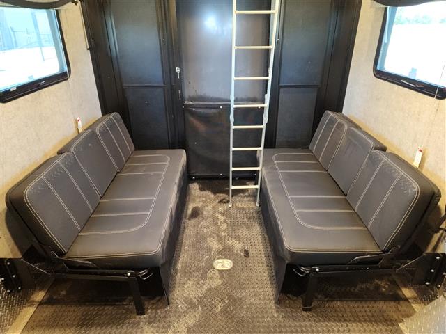 RV rental interior: Spacious toy hauler with two convertible sofas on sides and a central ladder, likely for bunk access.. Thor Motor Coach Outlaw 38KB 2022