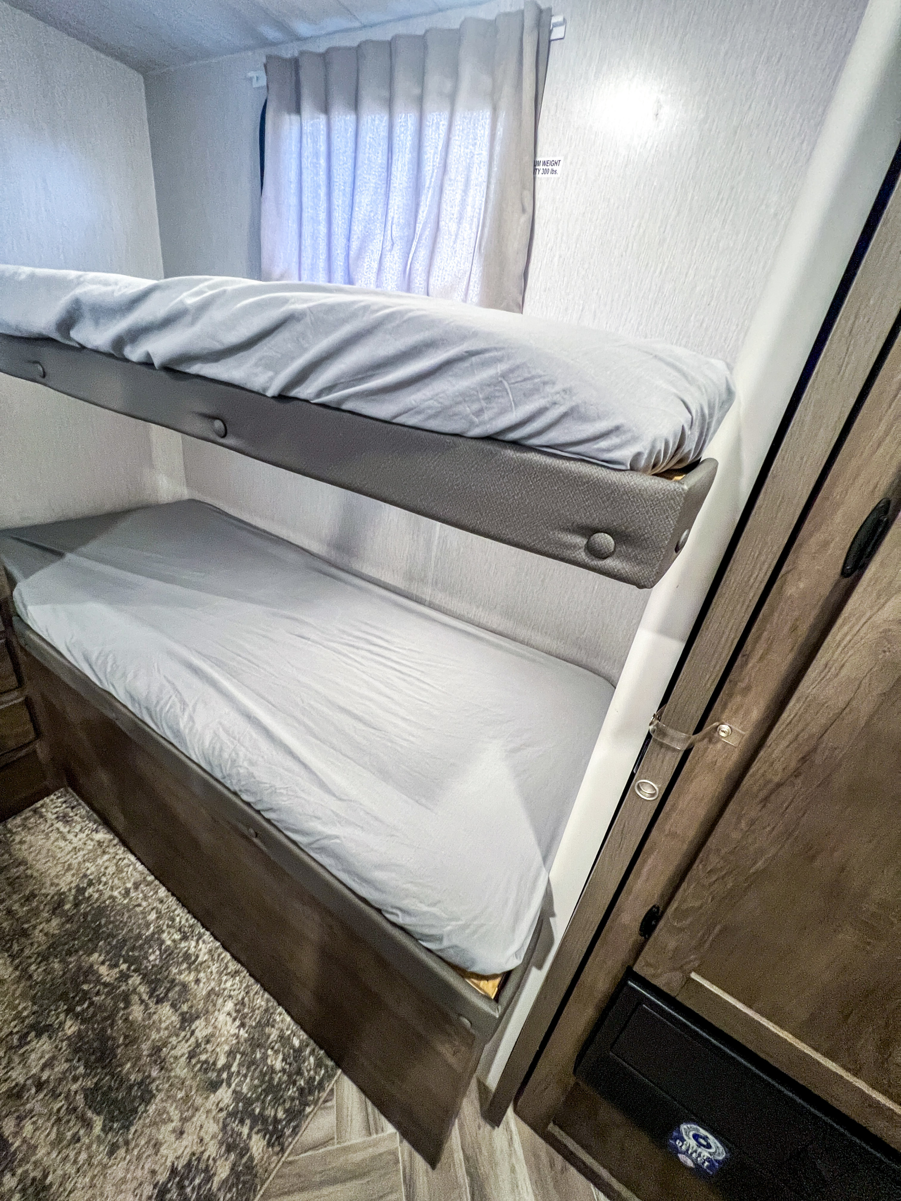Cozy RV rental bunk beds with soft grey sheets, designed for compact sleeping, with a 300 lb weight capacity.. Forest River Salem Cruise Lite 2022