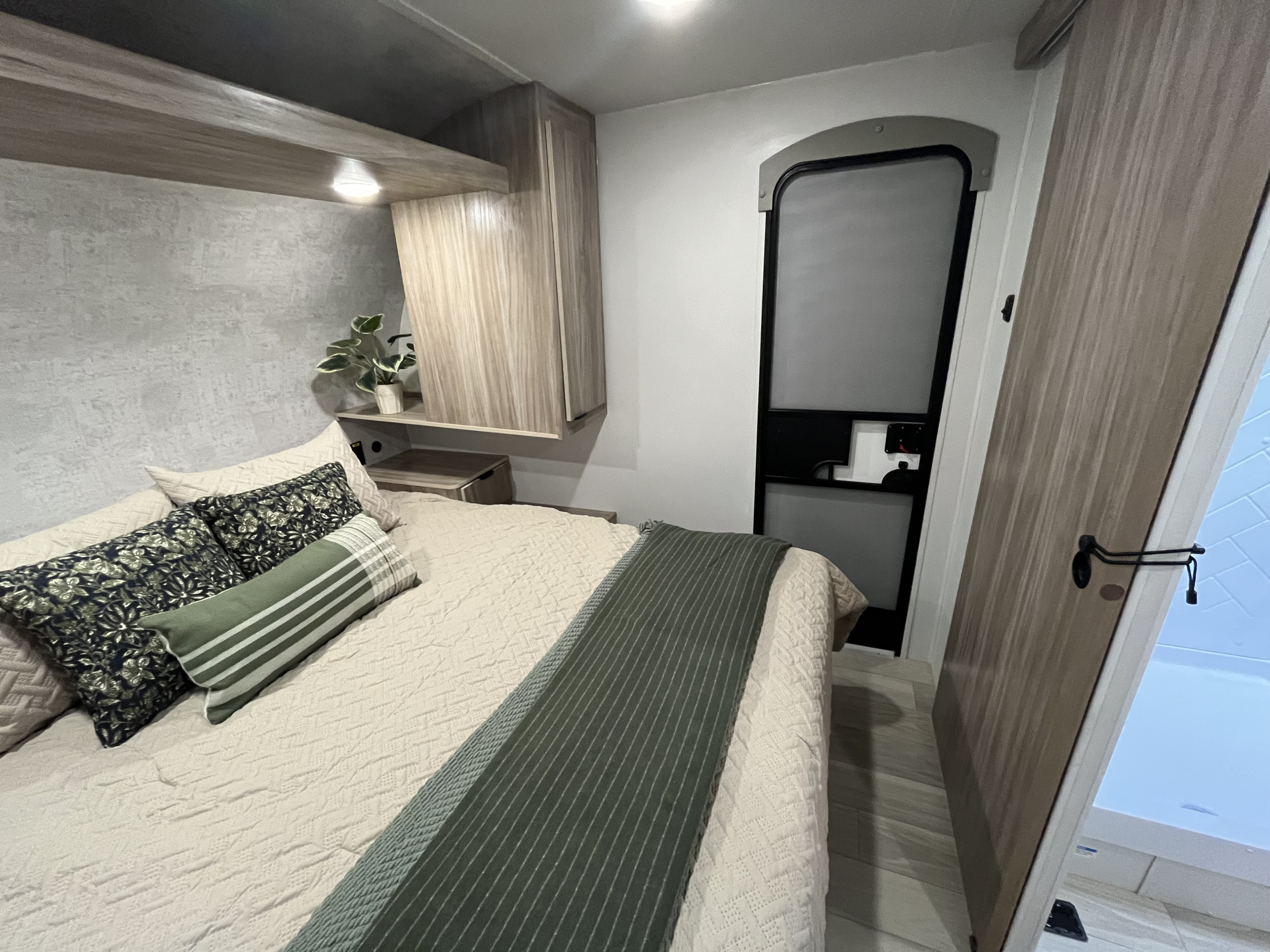 Experience comfort in this modern RV rental bedroom. Features a queen bed, overhead storage, and a stylish, compact interior.. Winnebago Access 26 RL 2024