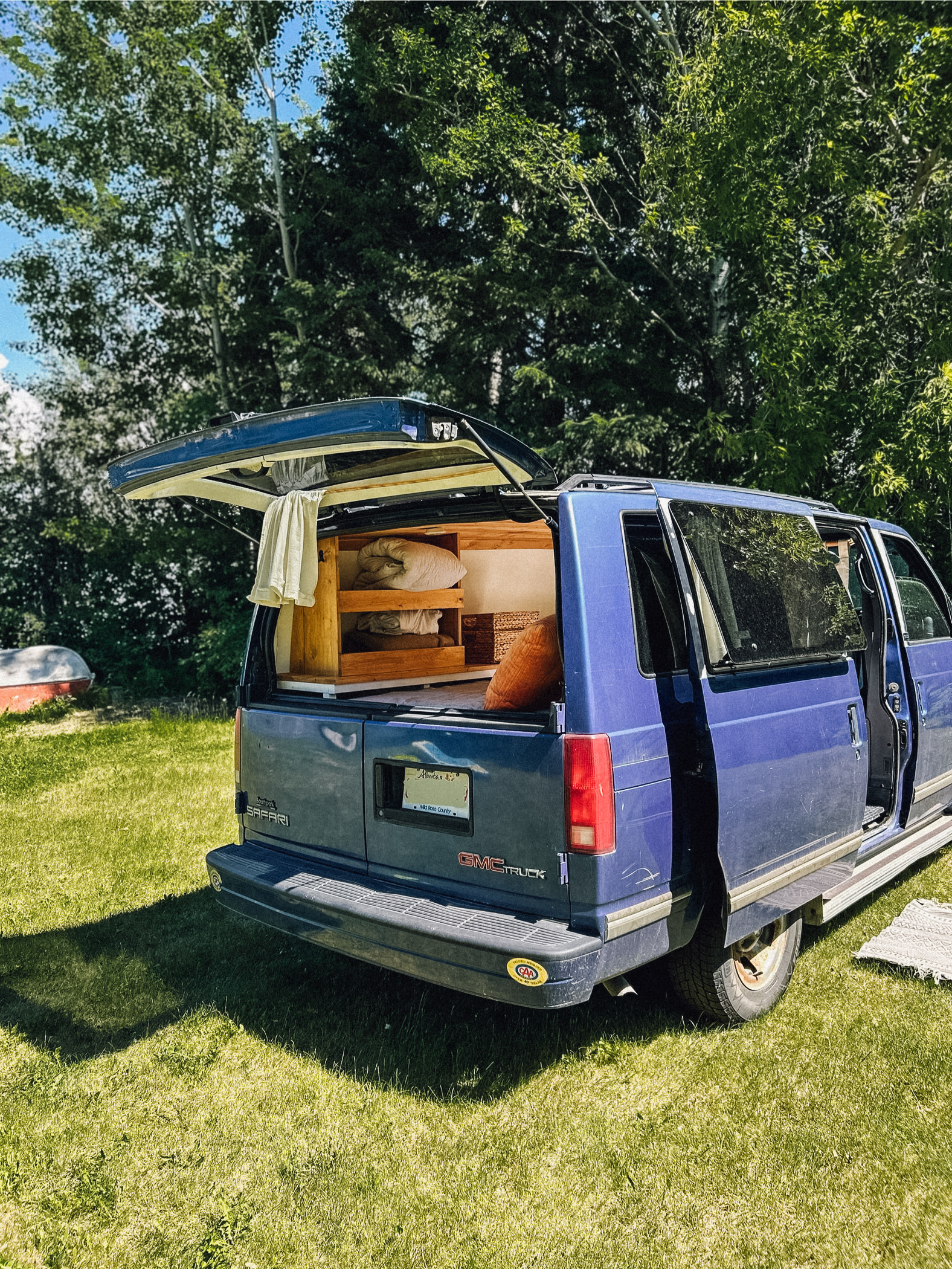 Blue GMC Safari van converted for camping, showcasing its interior setup. A great RV rental option for nature lovers.. Gmc Safari 1996