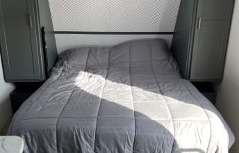 Cozy RV rental bedroom with a comfy bed and built-in storage. Ideal interior accommodations for travel.. Keystone RV Bullet Crossfire 2022