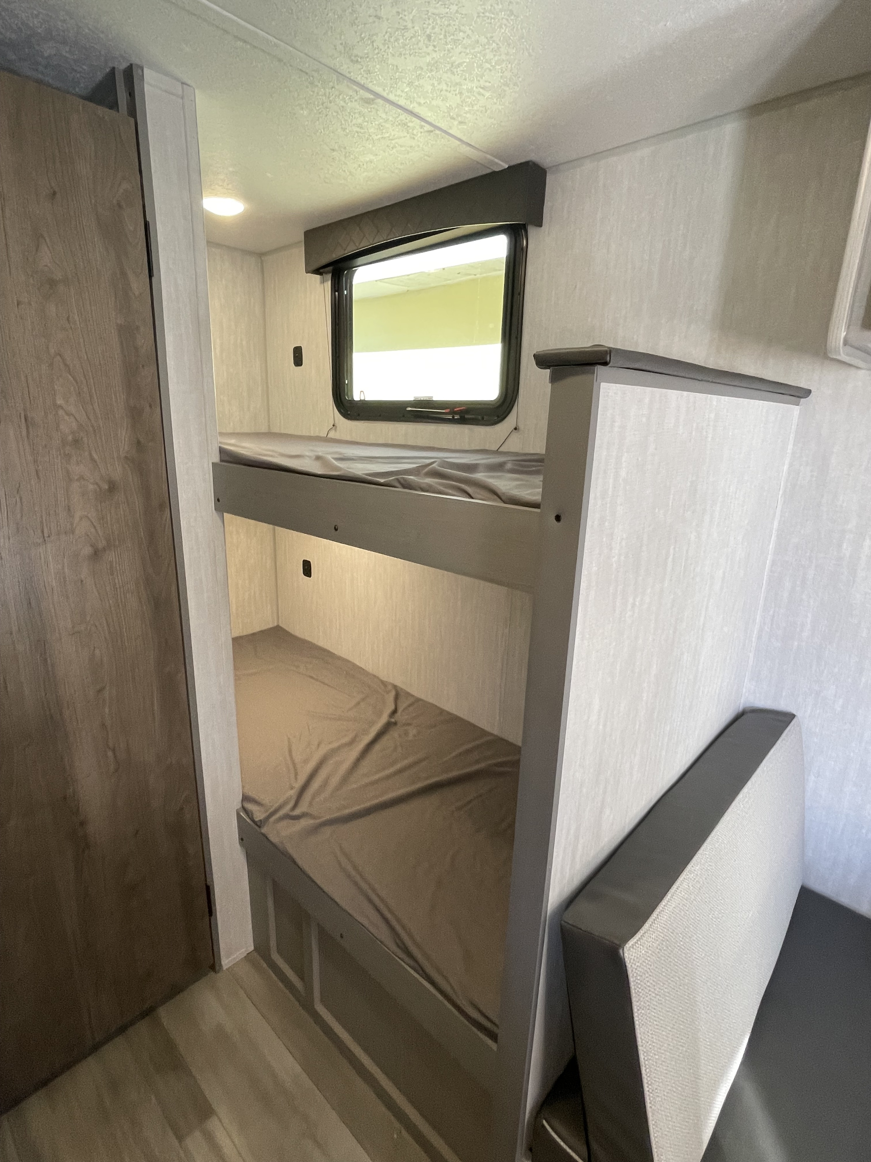 Cozy RV rental interior featuring bunk beds and a window, providing a comfortable sleeping space for your adventures.. Coachmen Clipper Cadet 17CBH 2025
