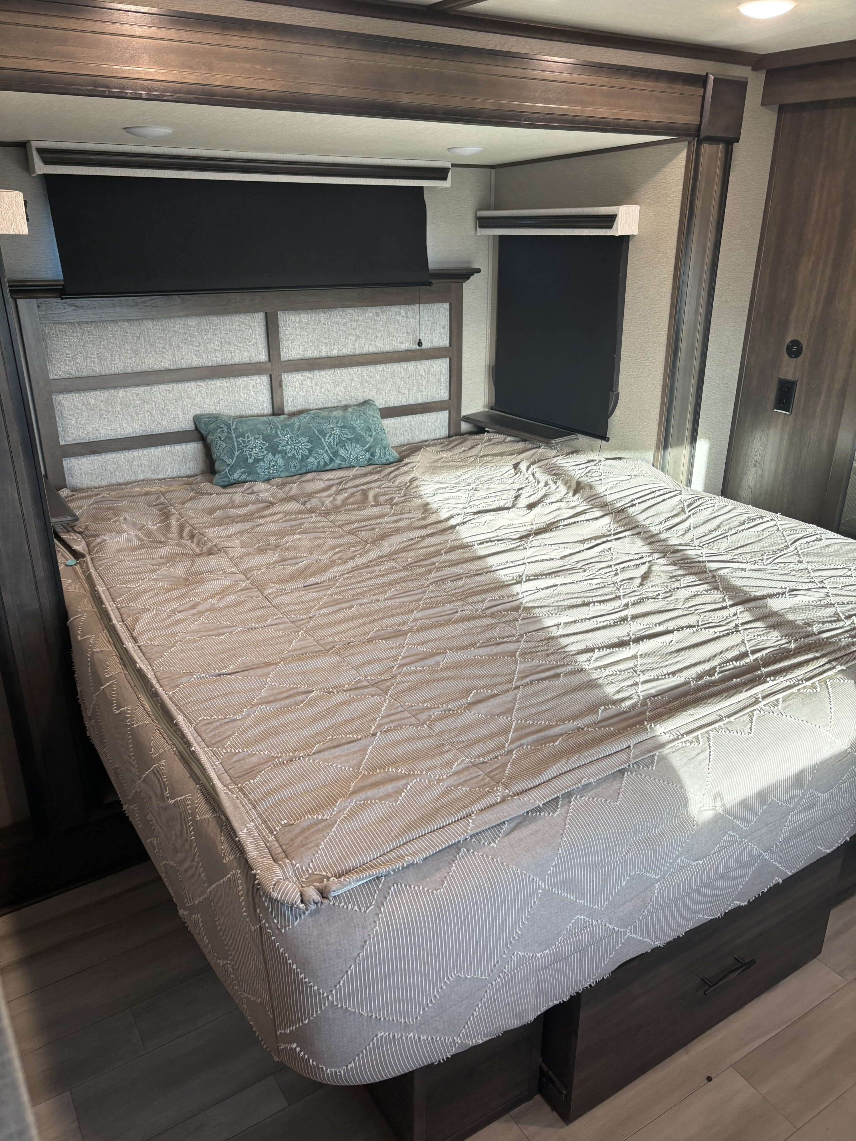 RV rental bedroom: cozy queen bed with blackout blinds, storage drawers, and stylish headboard.. Grand Design Solitude 2022