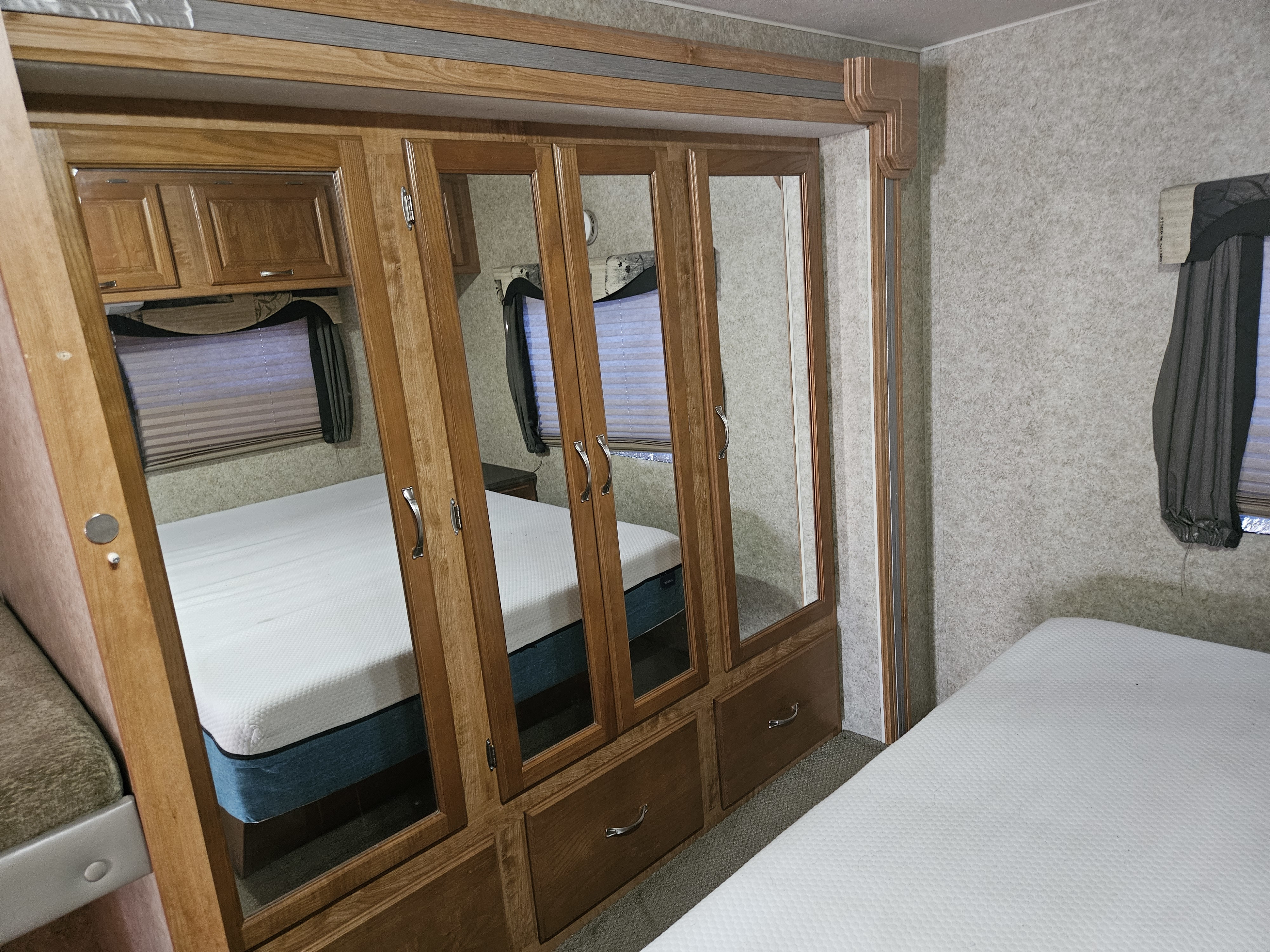 RV rental: Bedroom interior featuring two beds, mirrored closet doors, and warm wood accents. Ready for your trip.. Coachmen Mirada 2007