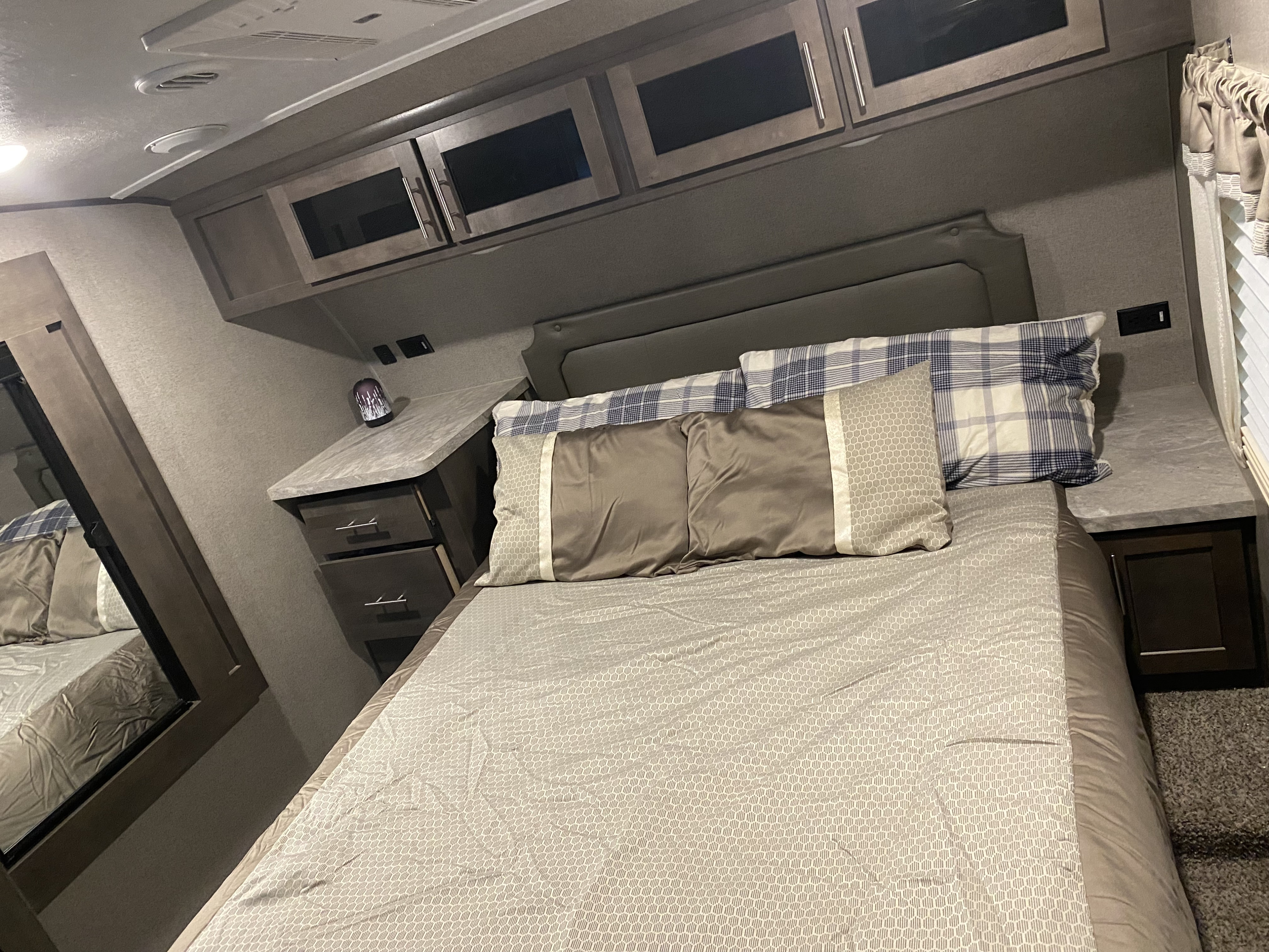 Explore this comfy RV rental bedroom, featuring a large bed, overhead storage, and handy nightstands.. Forest River Flagstaff Super Lite 2021