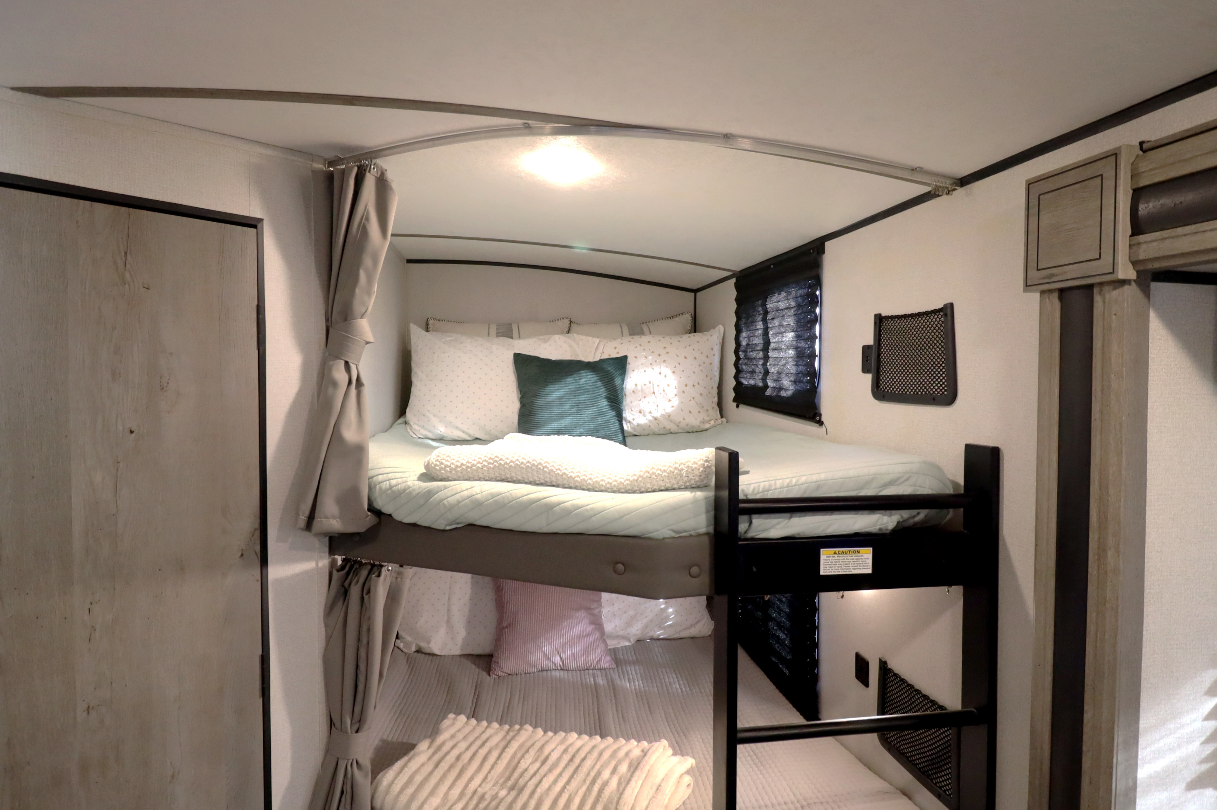 RV rental: Bunk beds with soft bedding and privacy curtains, providing a compact, comfortable sleeping space.. Keystone RV Springdale 2021