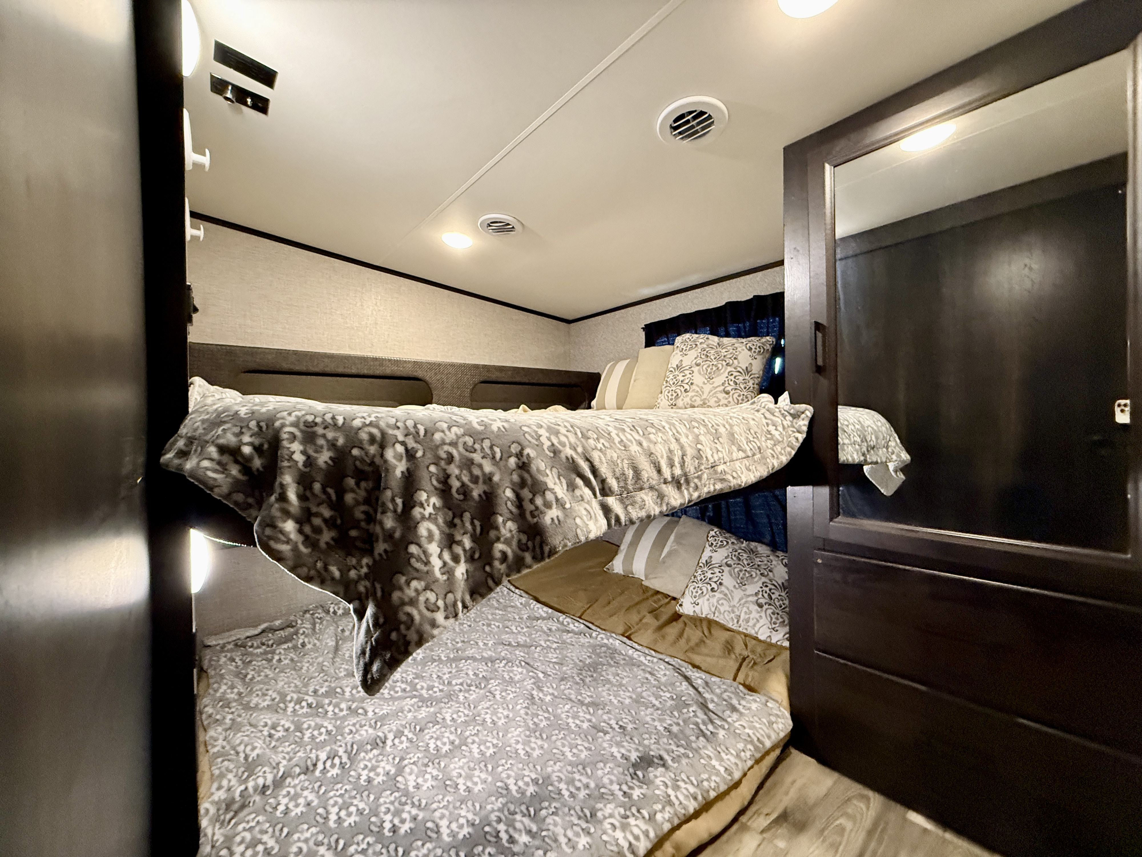 Cozy bunk beds in an RV rental with patterned bedding and soft lighting. Ideal for family travel.. Jayco Jayco 2022