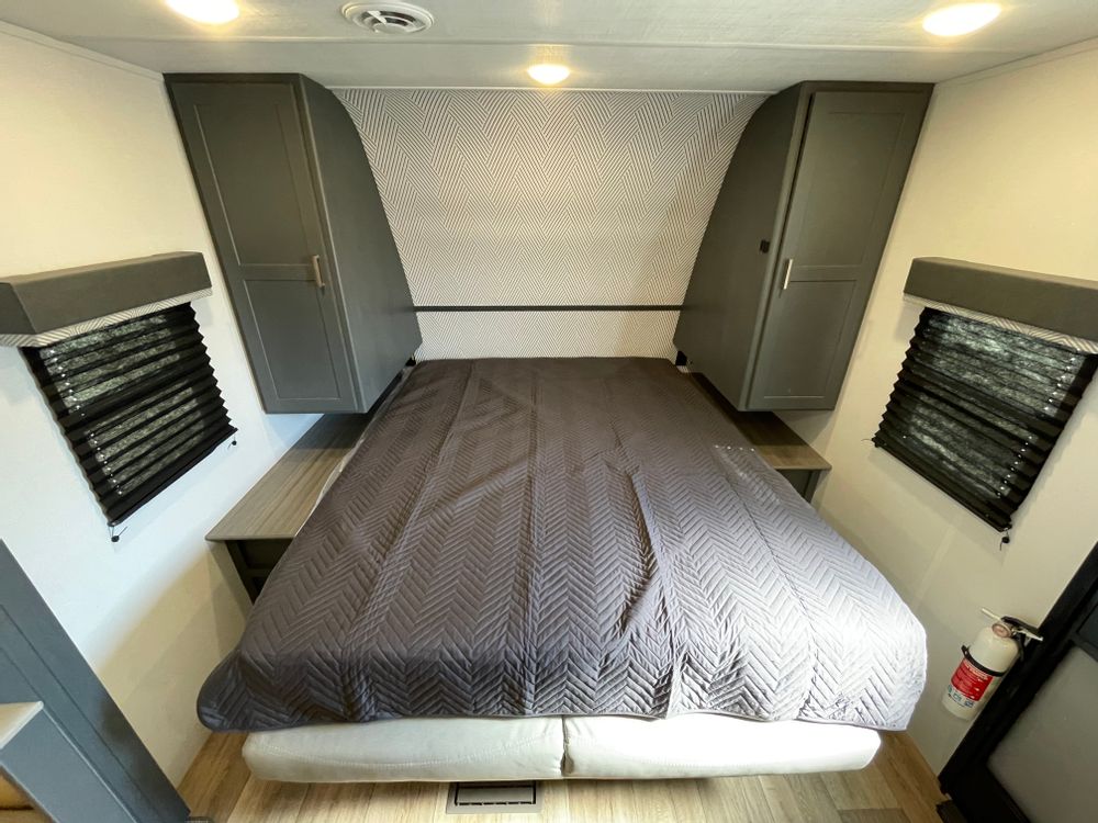 RV rental bedroom: Features a comfortable bed, built-in storage cabinets, and window blinds for privacy.. Keystone RV Bullet Crossfire 2024