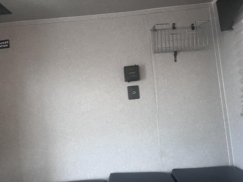 RV rental interior wall: Dometic thermostat, charging port, and mounted wire basket for organization.. Sunset Park RV SunRay 2021