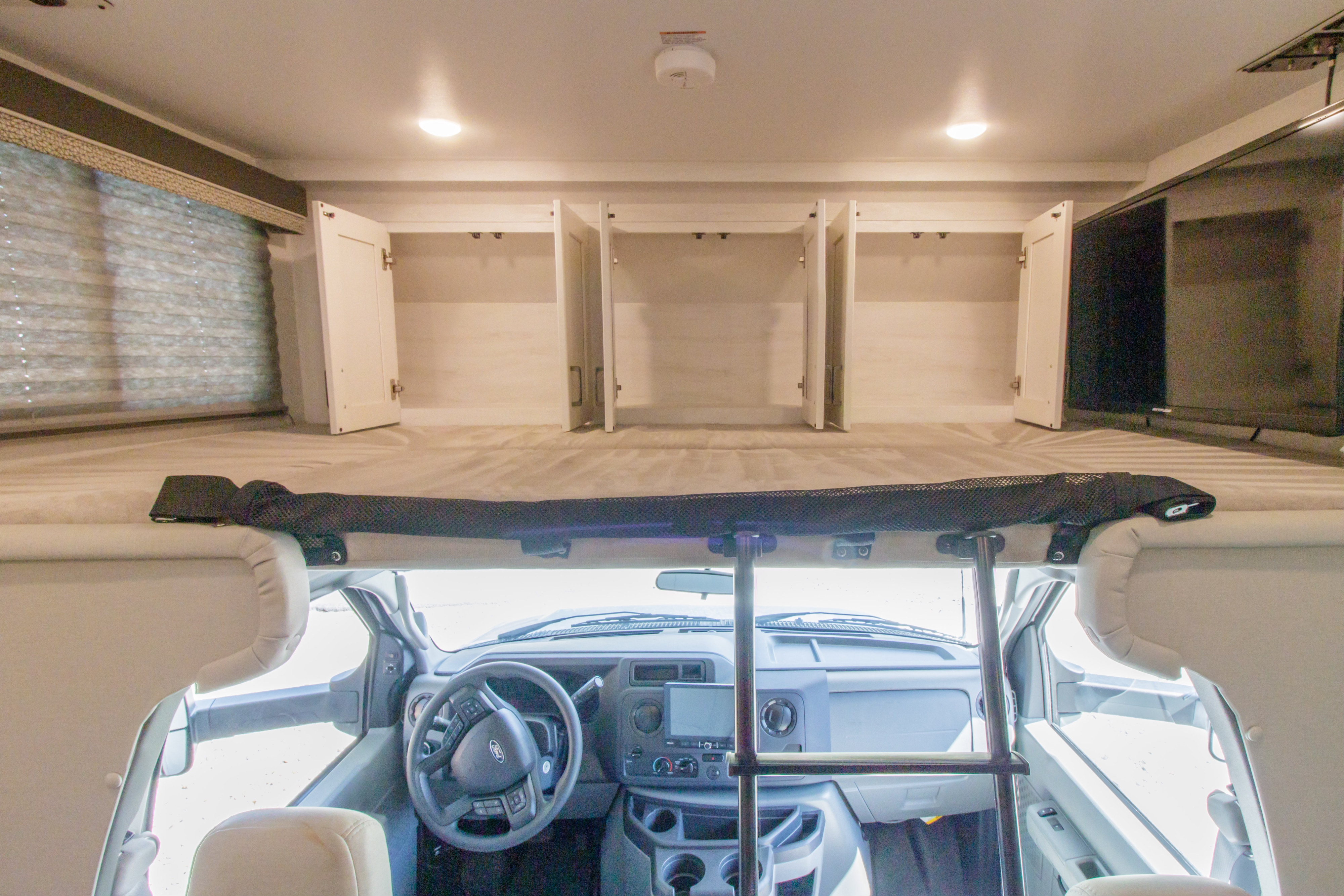 Experience RV rental comfort: view of the overhead bunk, open cabinets, TV, and front cabin.. GULFSTREAM CONQUEST 6238 2025