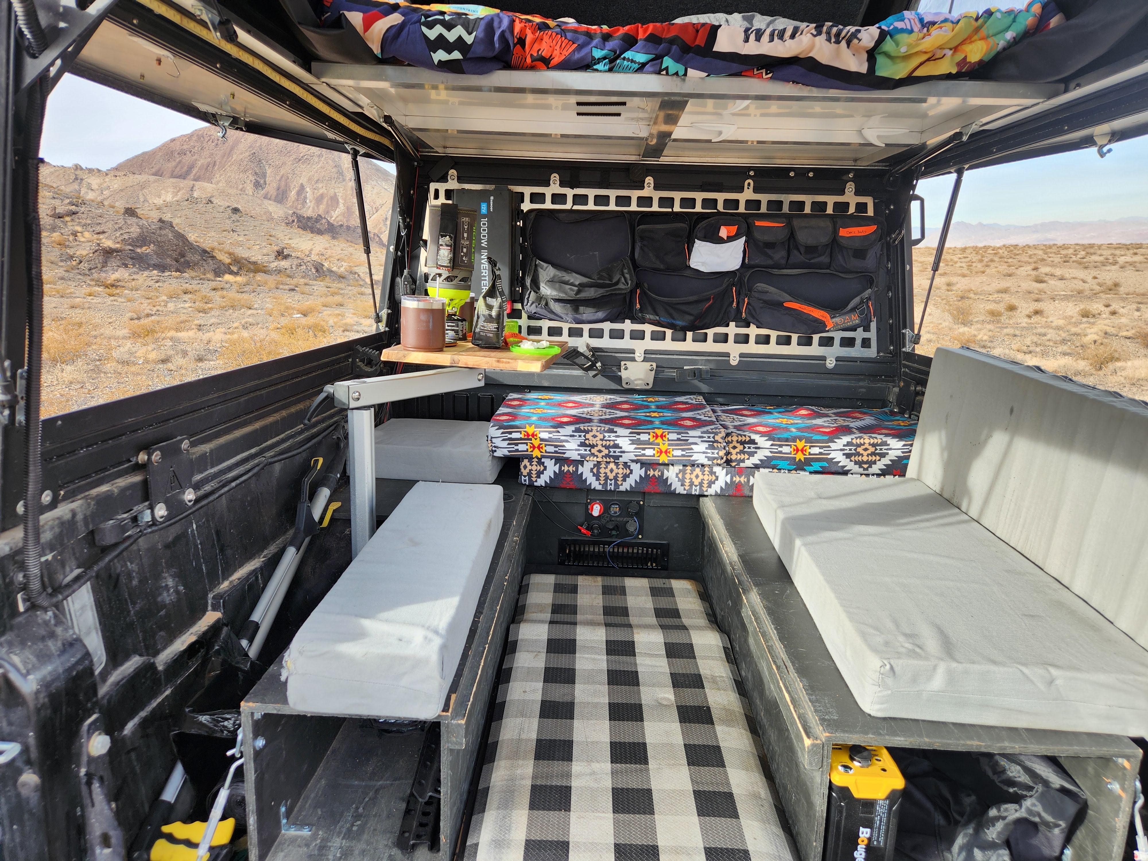 Custom truck camper interior with organized storage & cozy bed. Explore the desert – a versatile RV rental option.. Other Other 2021