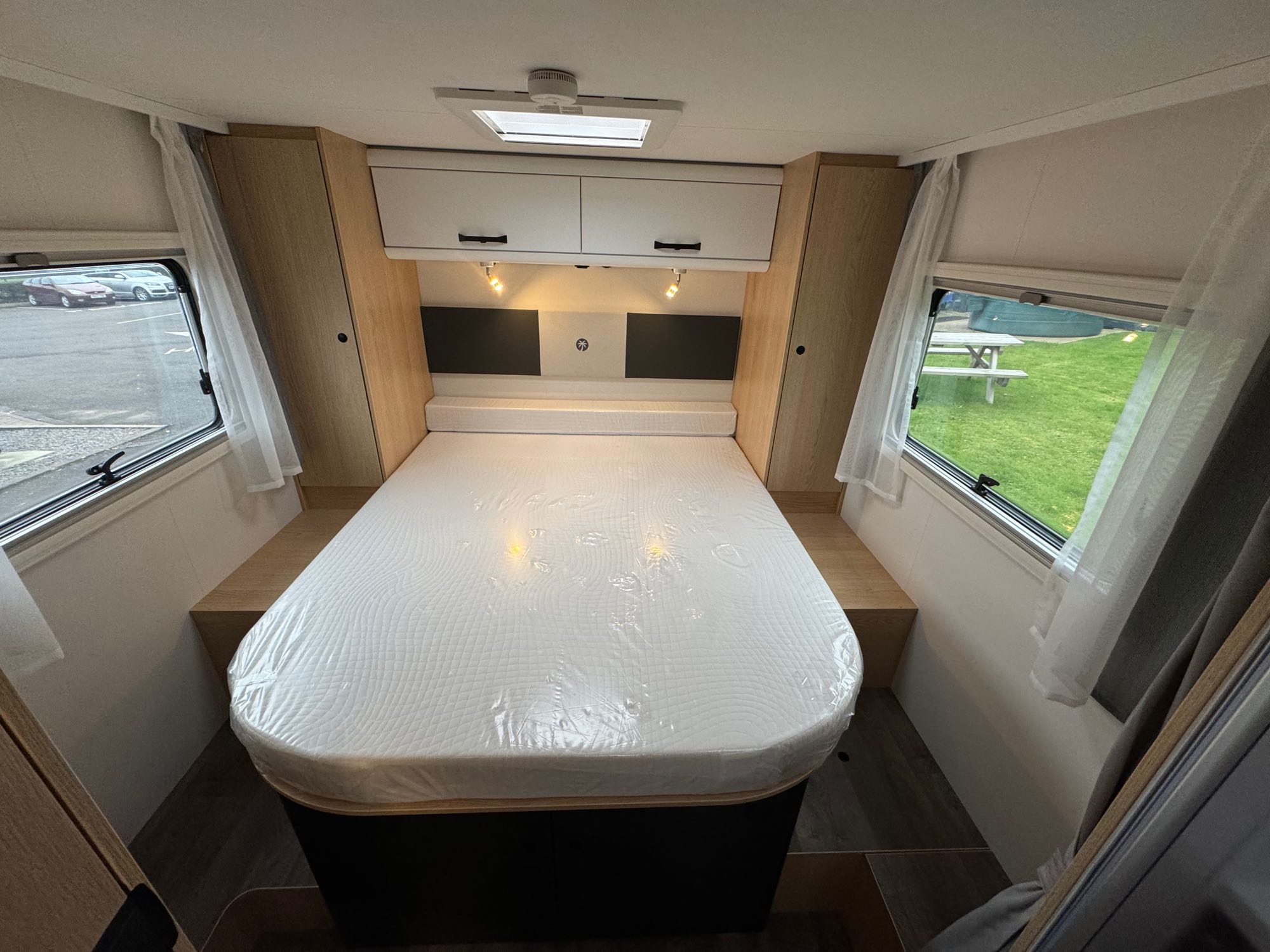 Bright RV rental bedroom: new mattress, overhead storage, side windows with views. Ready for your trip.. Sunlight 2025