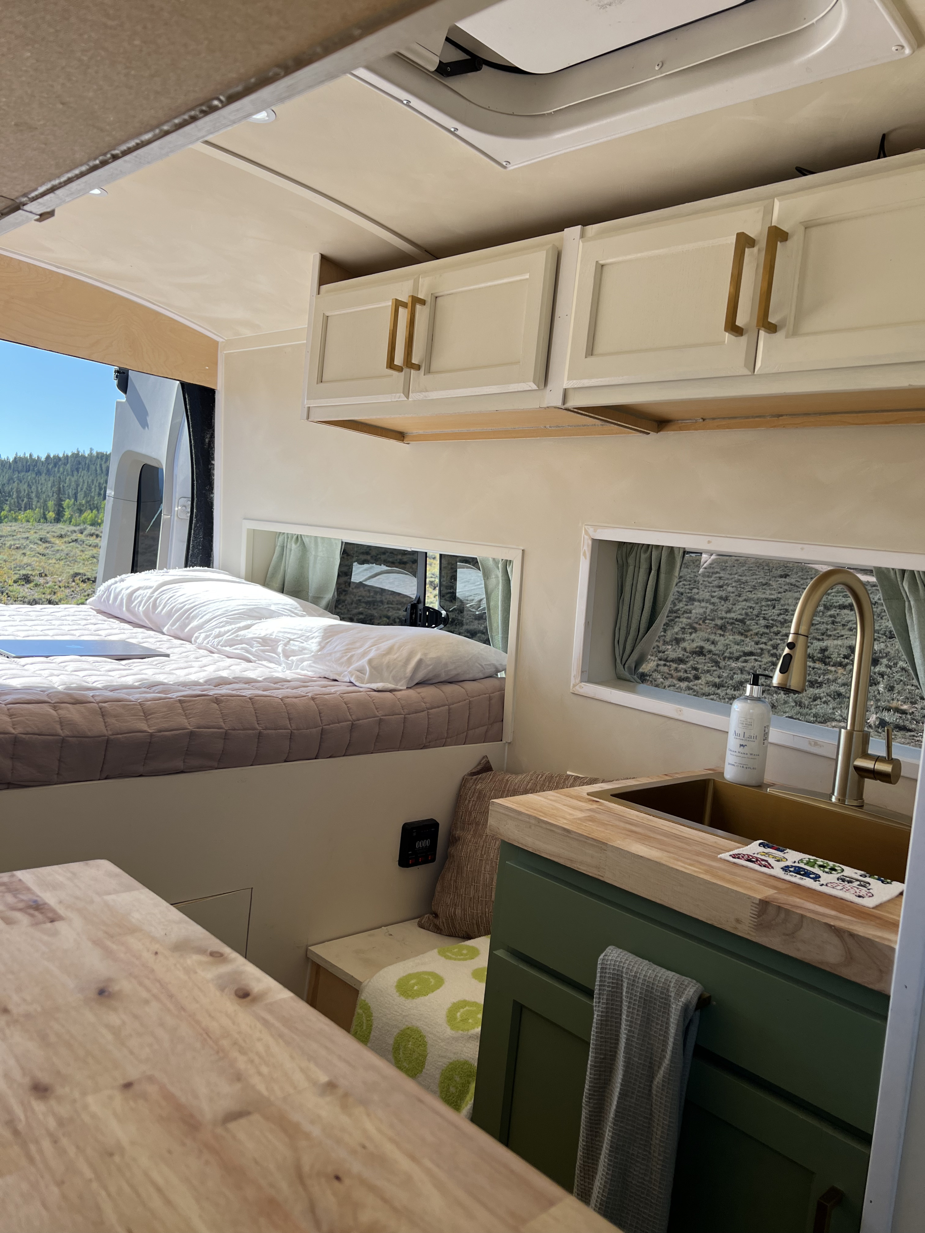 Explore the road in comfort! This RV rental features a cozy bed, full kitchen, and serene outdoor views.. Ford Transit 2016