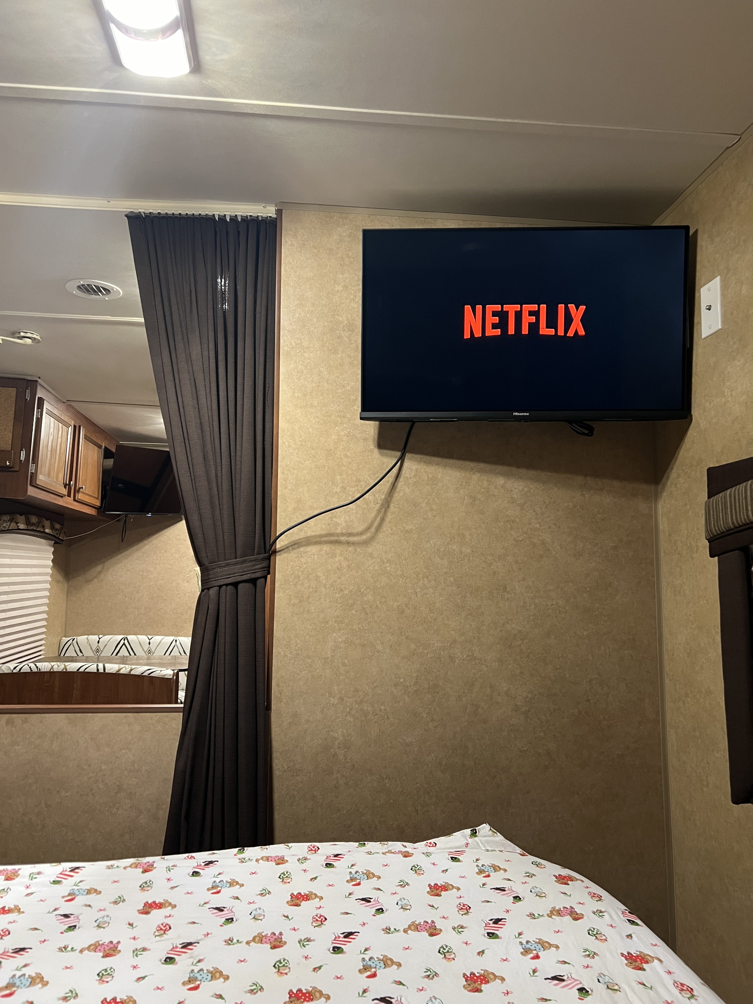 Experience comfort in this RV rental! A cozy bedroom features a mounted TV with Netflix, perfect for relaxation during your travels.. Jayco Jay Flight 2013