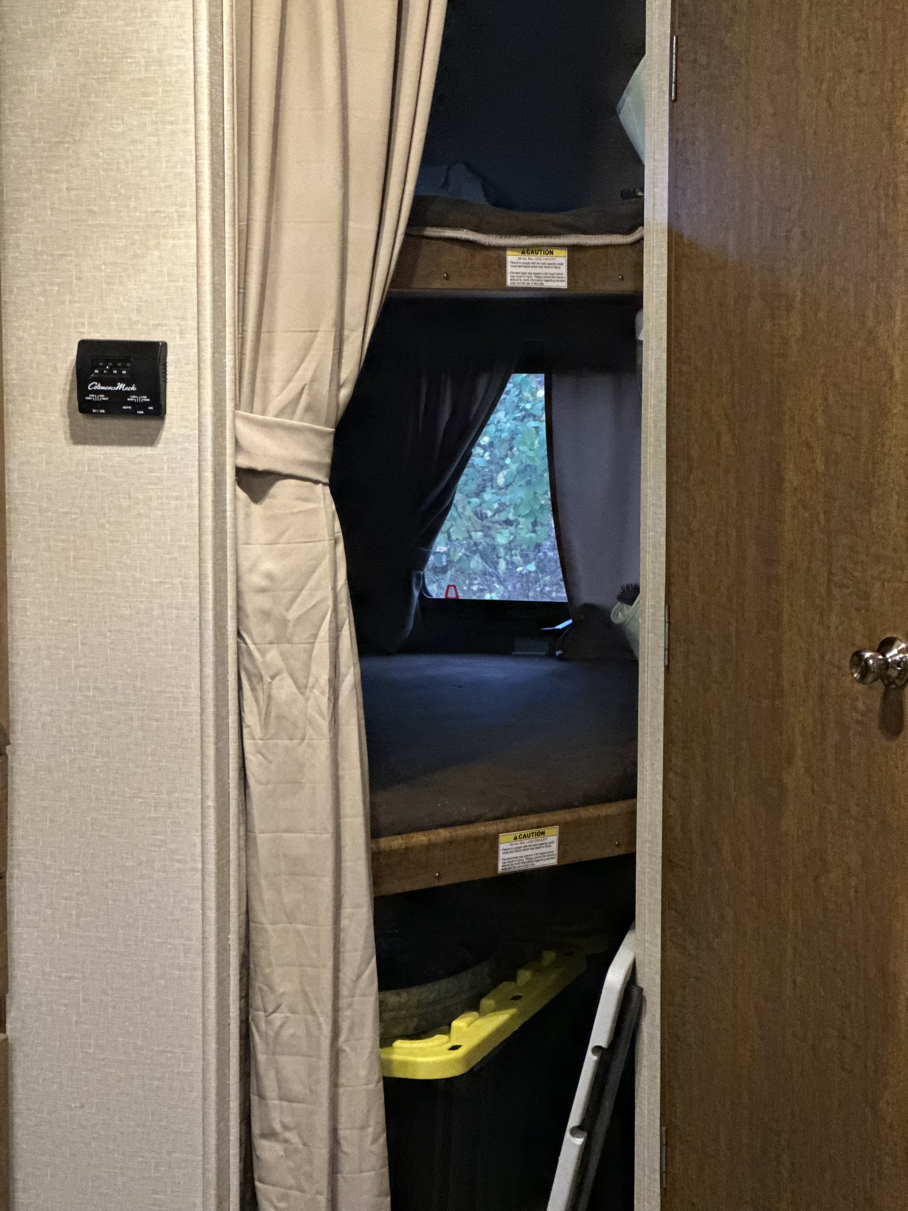 RV rental with bunk beds, privacy curtain, thermostat, and window view of trees. Perfect for a camper trip.. Crossroads RV Zinger 2016