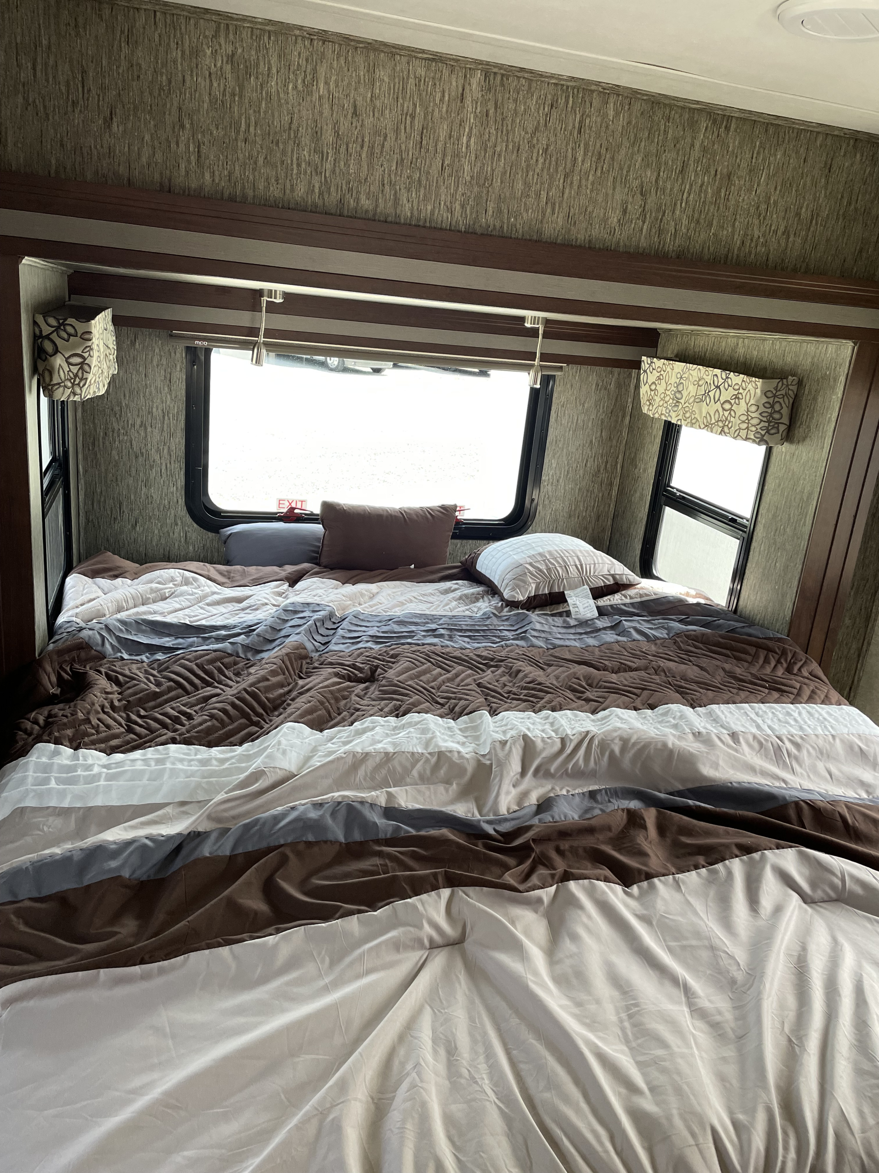 Comfortable RV rental bedroom, featuring a multi-tone striped comforter, perfect for restful road trip stays.. Forester MBS 2019