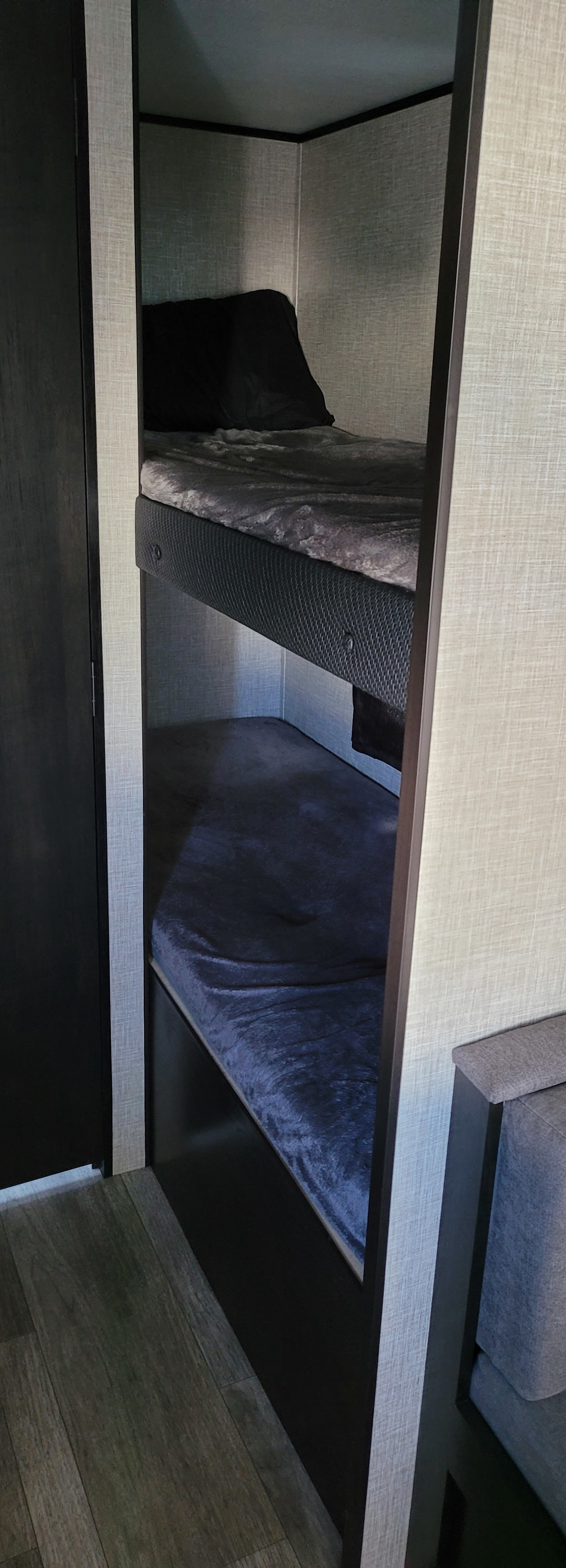 Cozy gray & blue bunk beds in an RV rental interior, ready for a compact family travel adventure.. Jayco Jay Flight SLX 2024