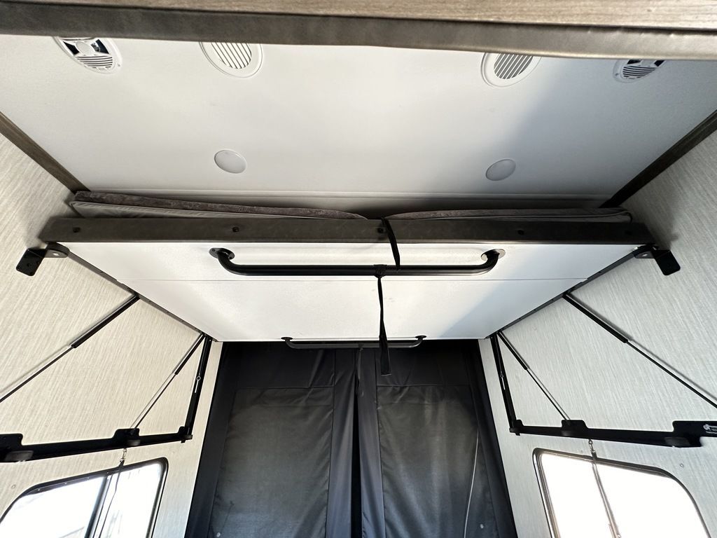 Compact RV rental interior featuring a clever fold-down bunk bed, optimizing space for sleeping or storage.. Forest River Vengeance Rogue Amored Toy Hauler 2021