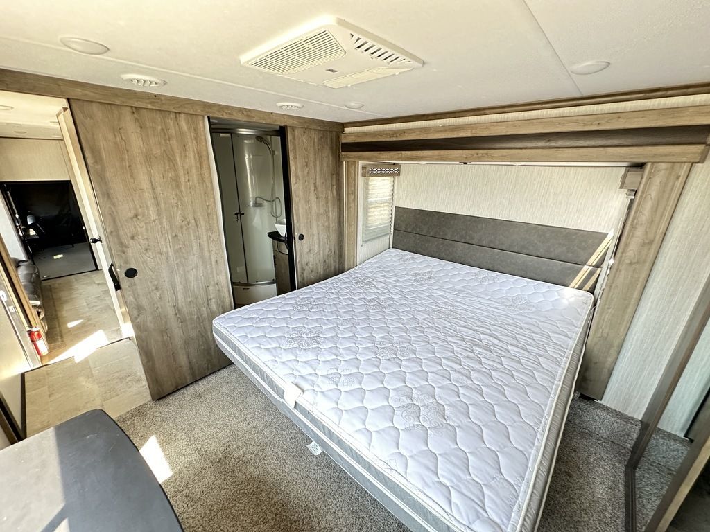 This RV rental offers a modern bedroom with a queen bed and an attached shower stall.. Forest River Vengeance Rogue Amored Toy Hauler 2021