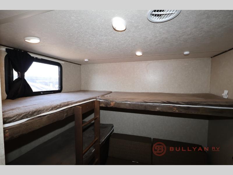 Spacious RV rental interior with comfortable bunk beds and a large window, ideal for family travel.. Forest River Vibe 2018