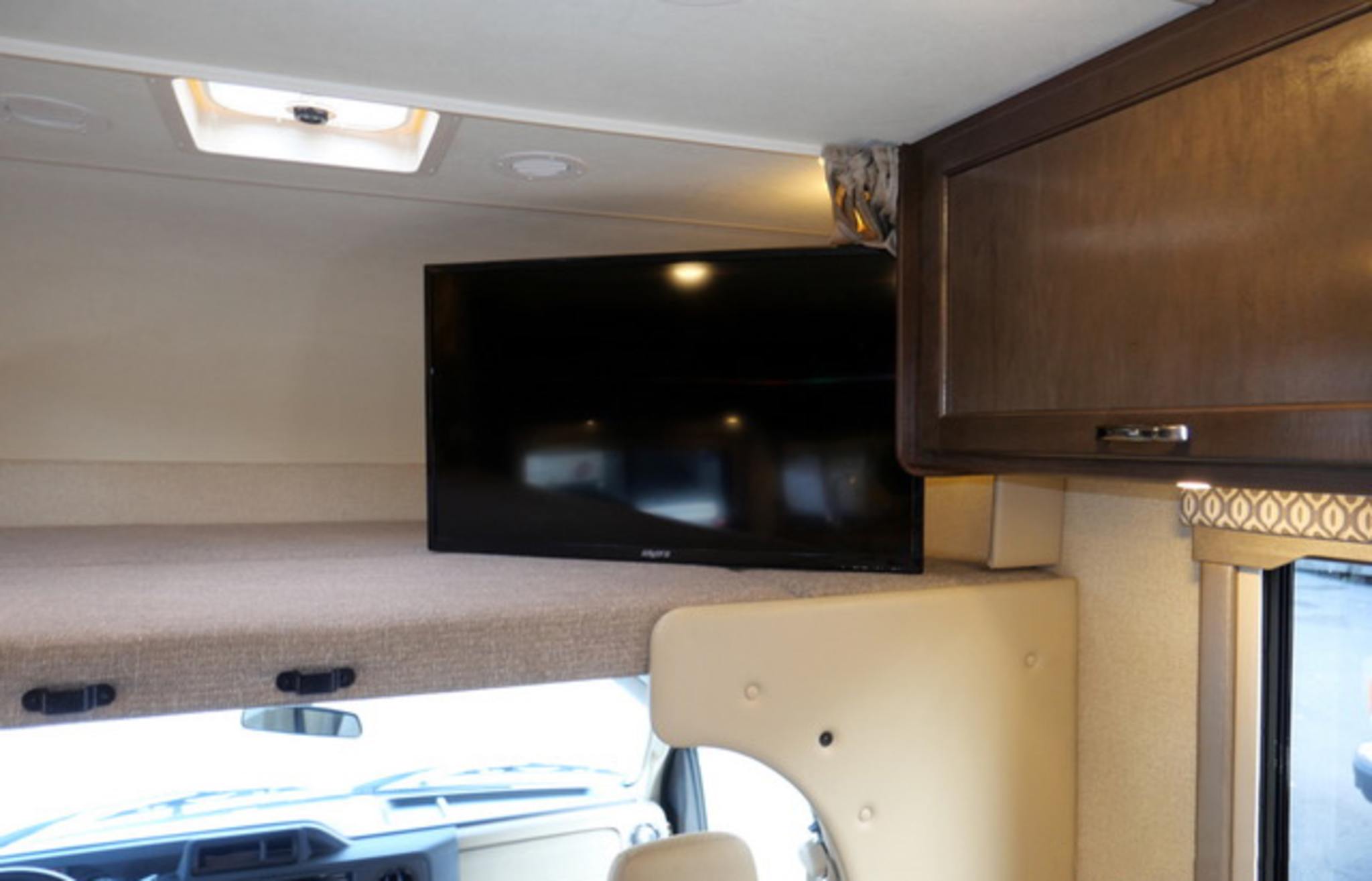 RV rental interior features an overhead sleeping bunk, flat-screen TV, skylight, and cabinets.. Thor Freedom Elite 2018