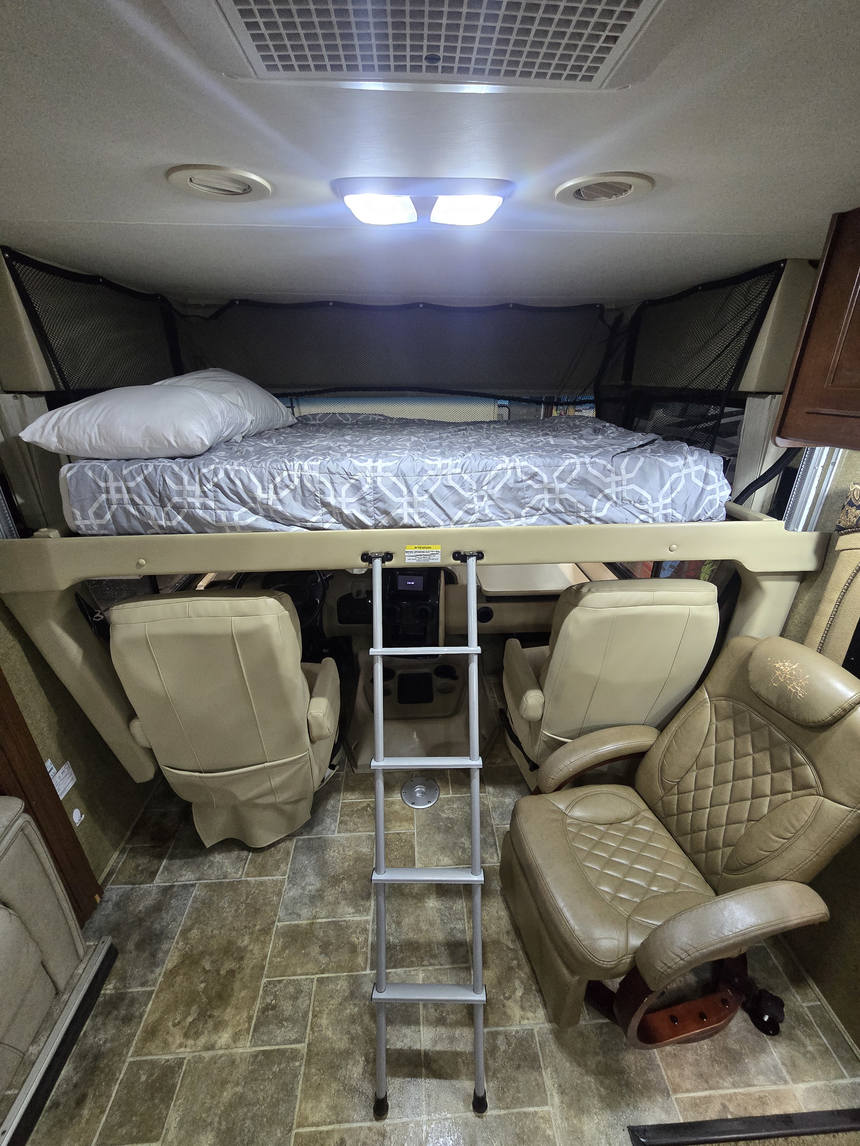 Inside this rv rental: an elevated bed, sturdy ladder, and two swiveling front seats for comfort.. Thor Motor Coach Miramar 2014