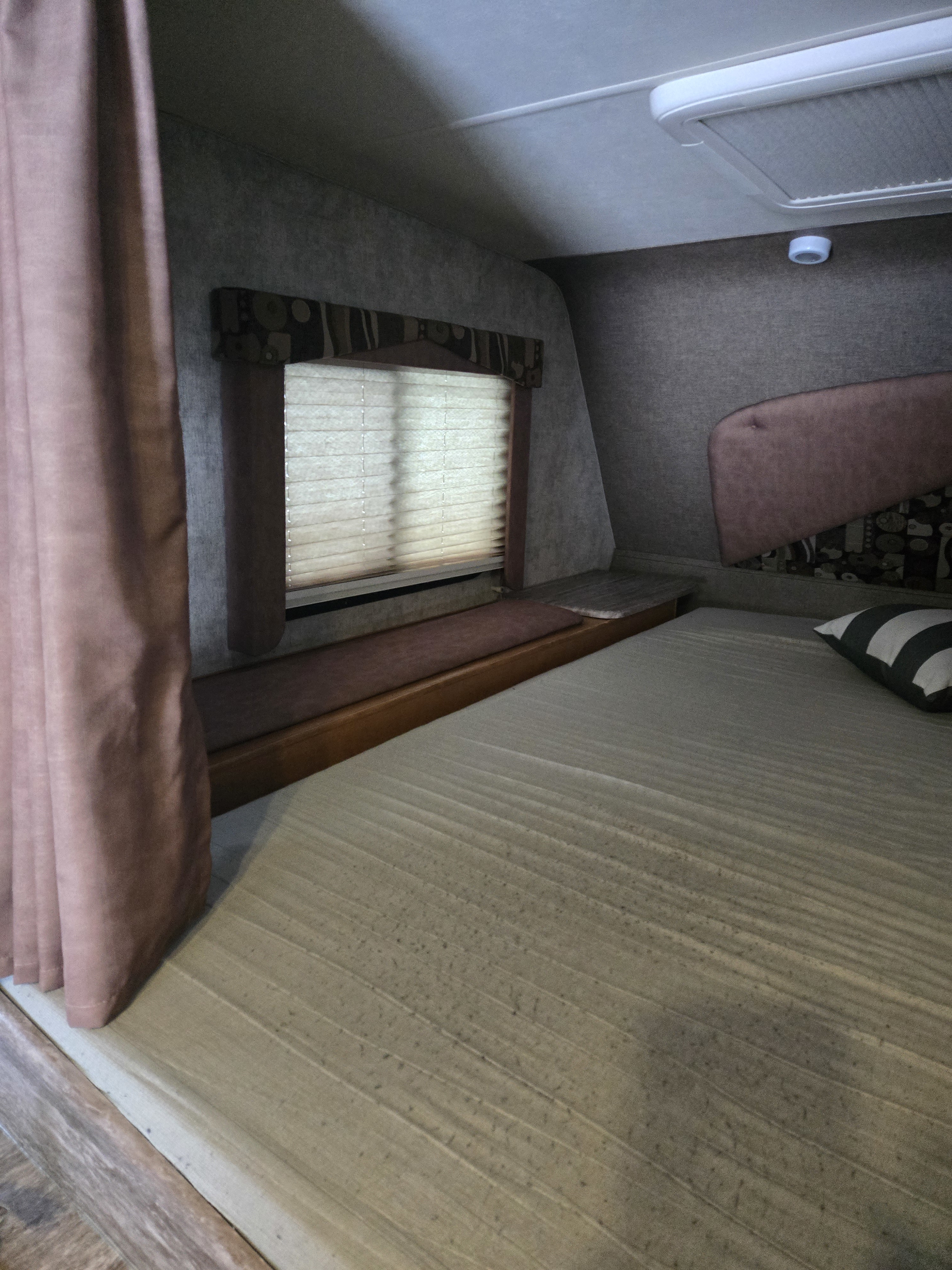 RV rental sleeping area: a comfortable bed, window with blinds, and warm curtains create a cozy space.. Adventurer Adventurer 2018