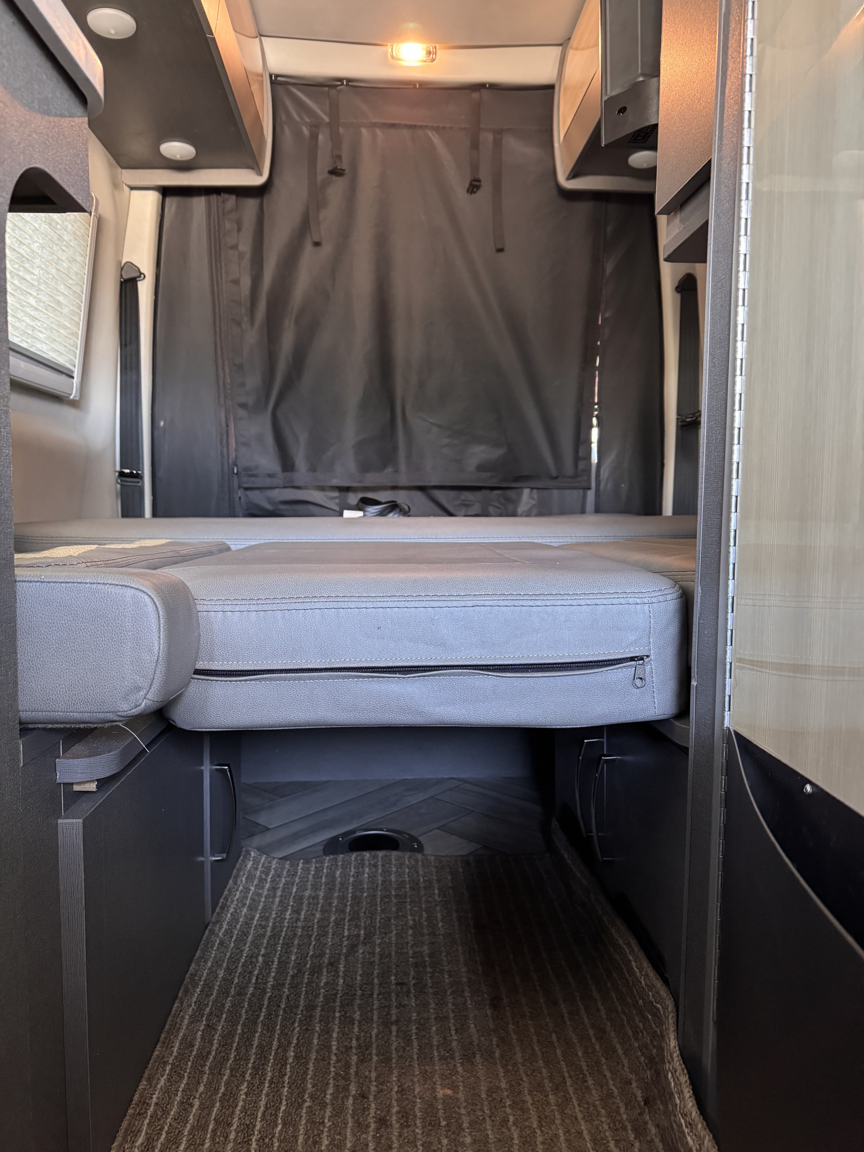 Experience comfort in this RV rental with its convertible bed, overhead storage, and rear privacy curtain.. Thor Sanctuary 2024
