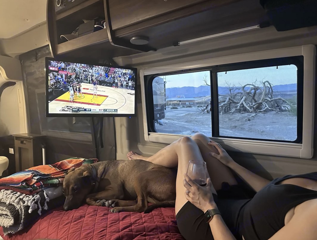 RV rental comfort: watching NBA with the dog & wine. Unique desert landscape outside, mountains afar. Cozy travel!. Winnebago Travato 2021