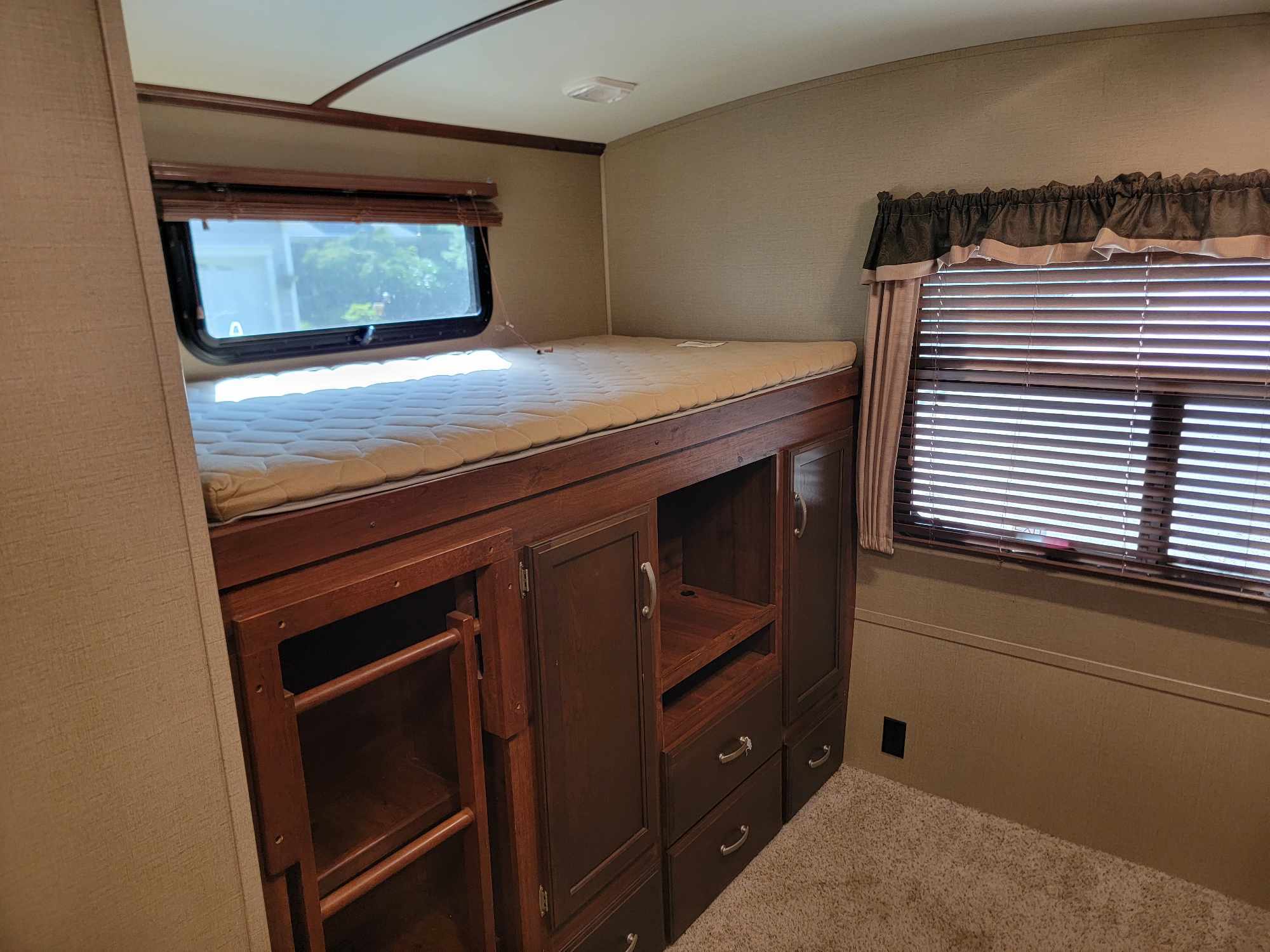 RV rental interior: Cozy bunk beds with ample storage and windows, perfect for family travel.. Keystone RV Outback 2014