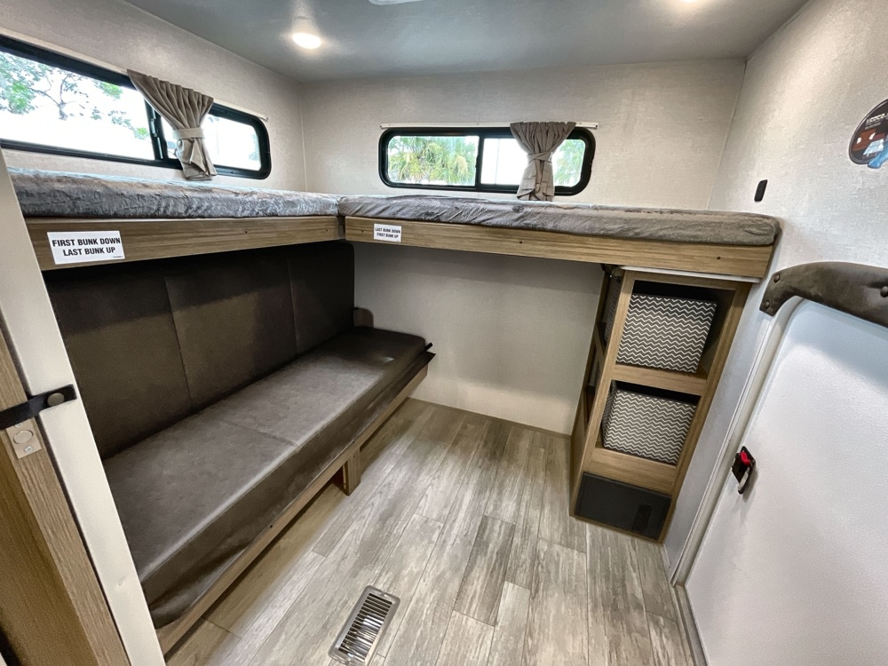 Spacious RV rental bunk room with L-shaped beds, a lower sofa bed, and built-in storage. Ideal for groups.. Forest River Salem 2025