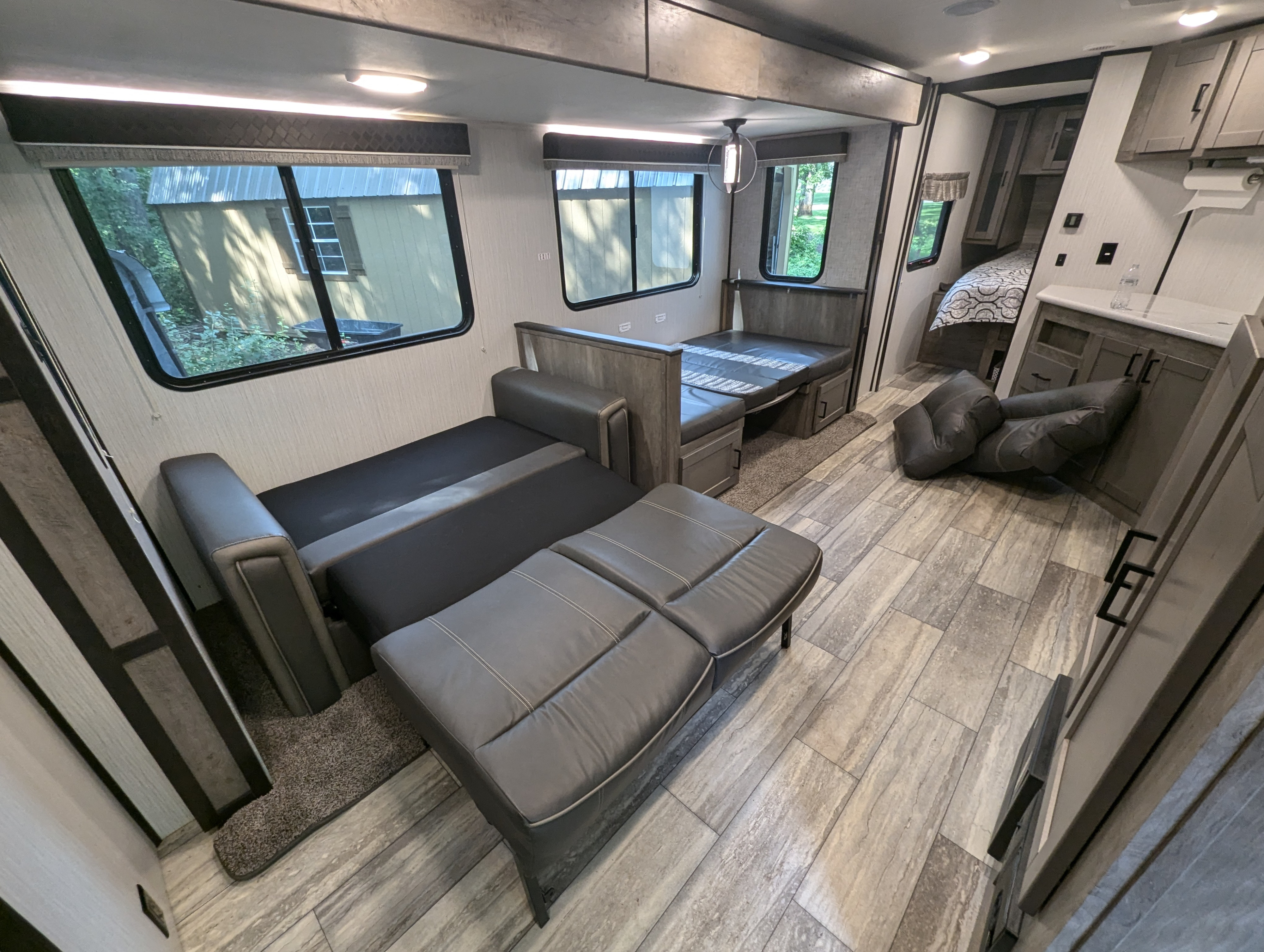Modern RV rental interior, featuring convertible sofa and dinette for versatile travel living.. Heartland RVs North Trail 2021