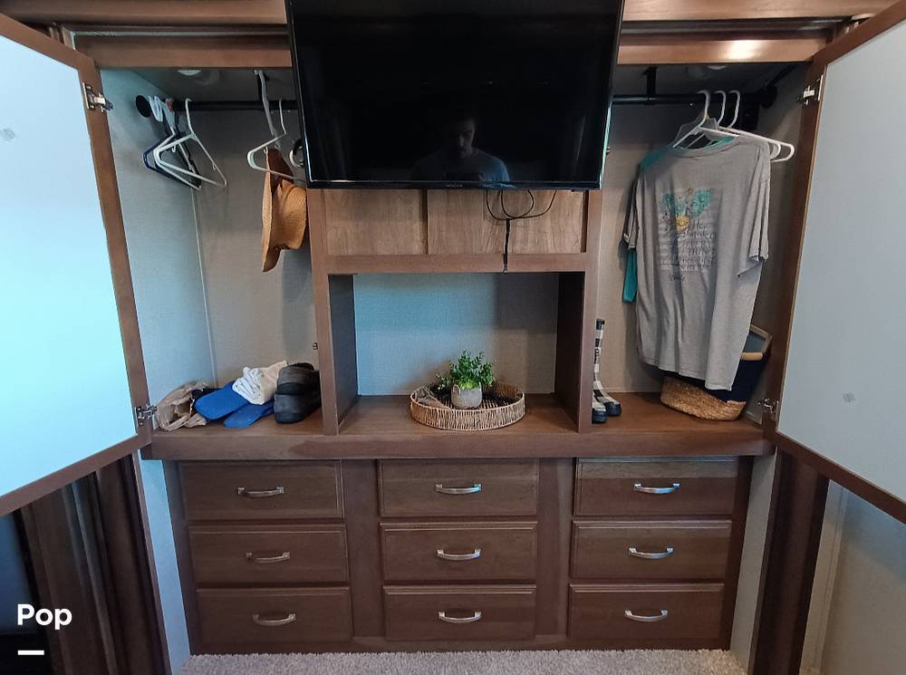 Explore an RV rental's clever storage: wardrobe with TV, hanging rods, and ample drawers for clothes and gear.. Keystone Montana 2018