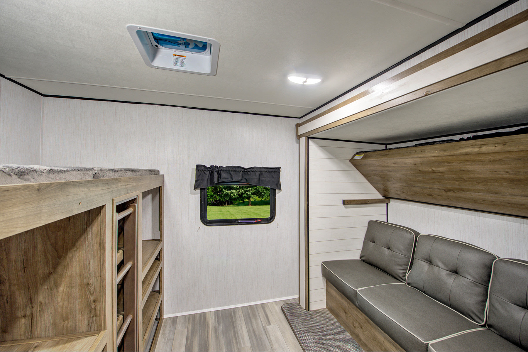 This RV rental features a cozy bunk bed setup, a comfortable sofa, and an additional fold-down bunk, offering versatile sleeping space.. Heartland RVs Pioneer 2022