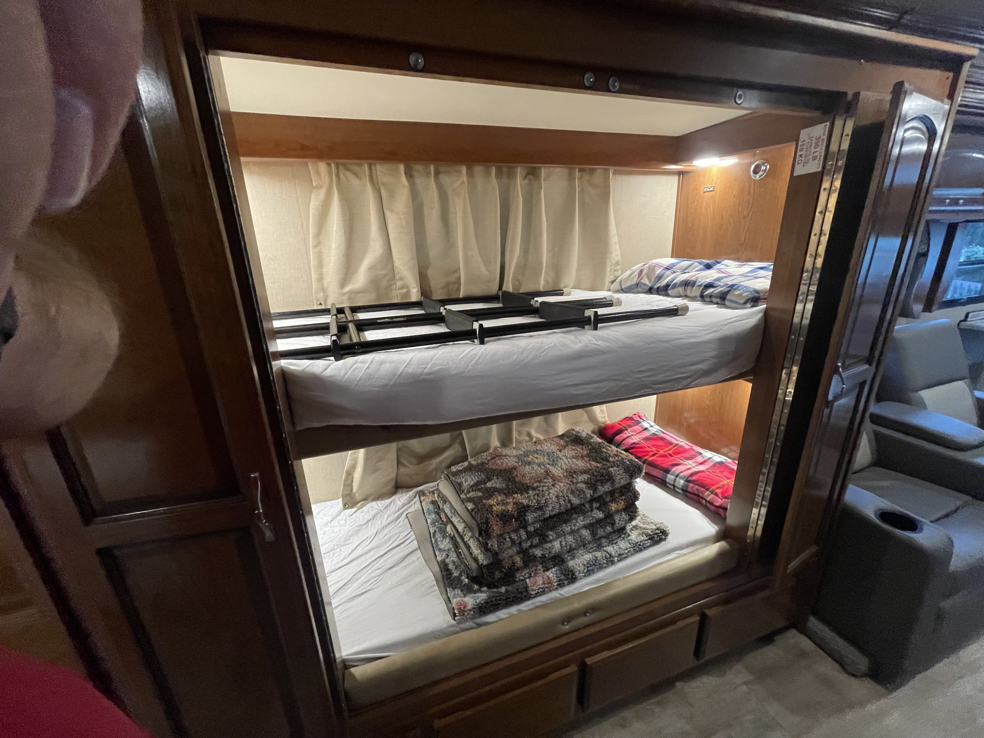Cozy bunk beds in an RV rental, providing comfortable sleeping for multiple passengers.. Holiday Rambler Vacationer XE 2018