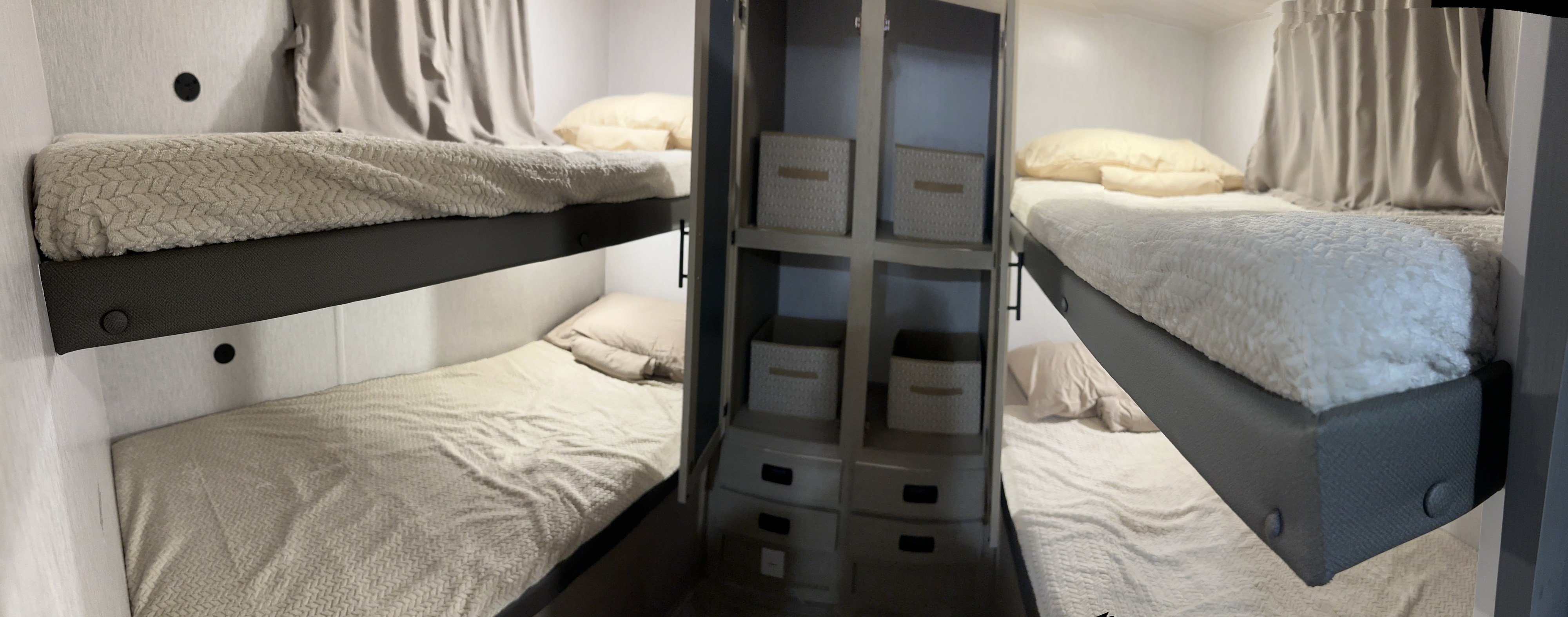 Inside an RV rental: two neatly made bunk beds and a storage cabinet with woven baskets, providing cozy sleep and organization.. Forest River Salem Cruise Lite 2024