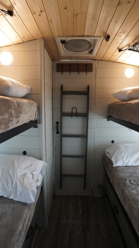 RV rental sleeping area featuring two sets of bunk beds, wooden ceiling, and a central ladder.. Bluebird TC3000 2008