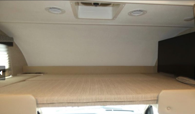 RV rental: Overhead bunk bed with ceiling vents, light, and TV for a comfortable stay.. Thor Four Winds 2023